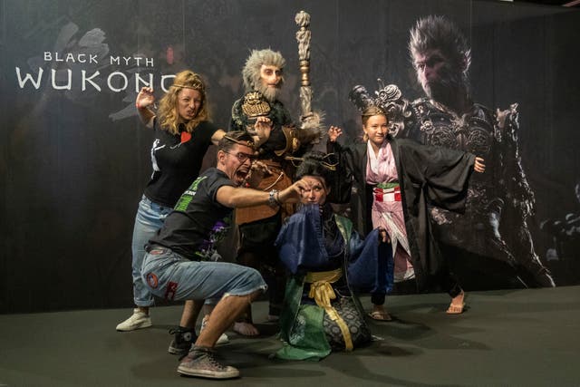 <p>People take photos in front of a poster of ‘Black Myth: Wukong’ at the Game Science display during Gamescom 2024 in Cologne, Germany, on 22 August</p>