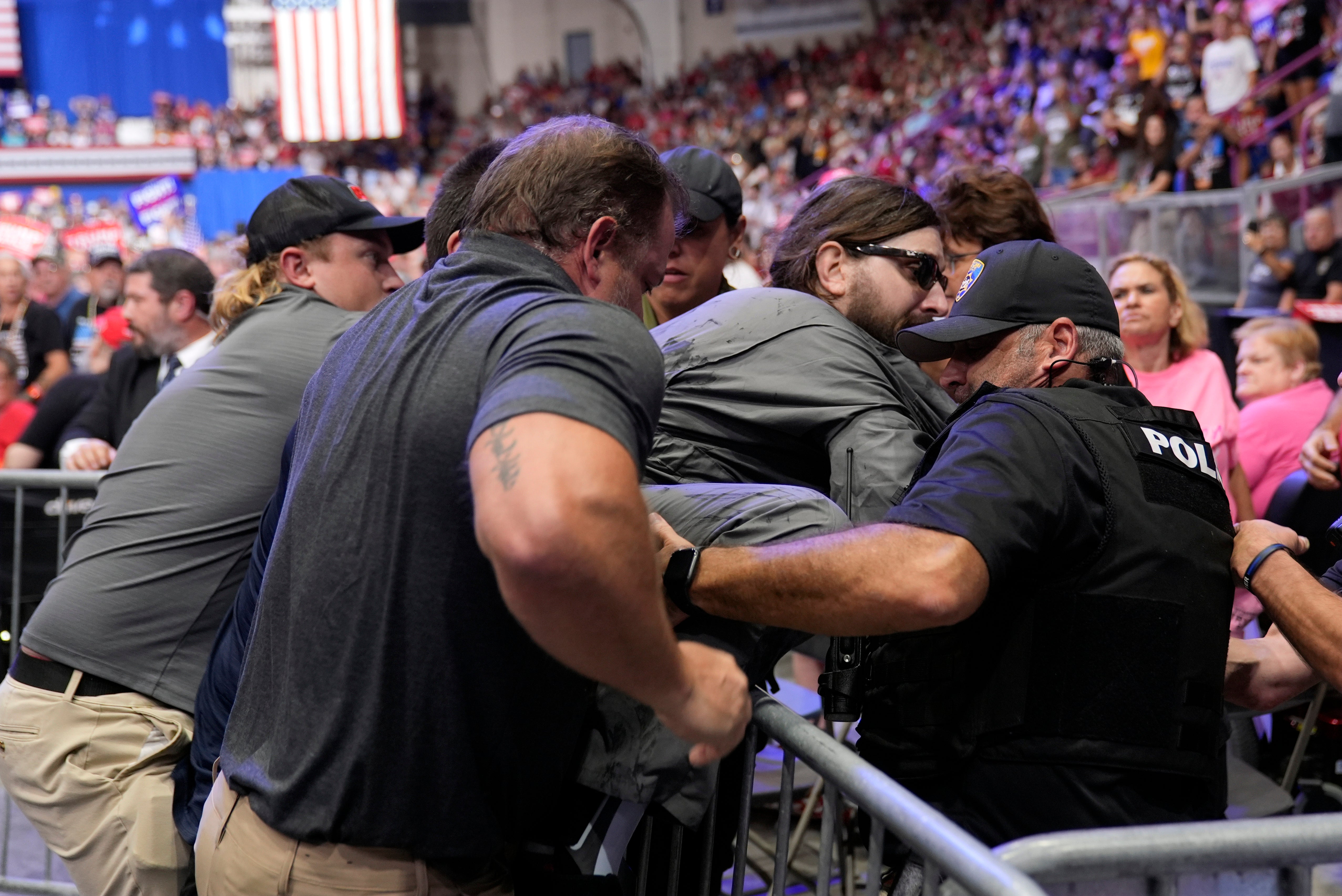 A man is tackled by law enforcement after he storms into the press area at Trump rally