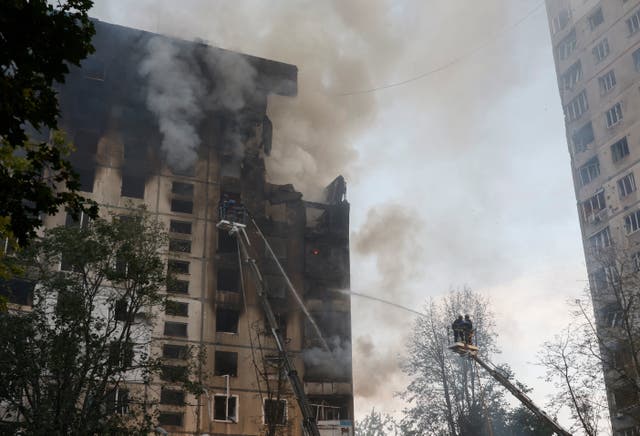 <p>Ukrainian rescuers work at the site of a damaged 12-story residential building following a missile strike in Kharkiv</p>