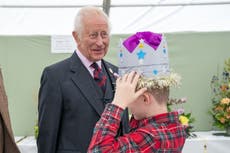 Schoolboy tries on prize-winning cardboard crown in front of the King