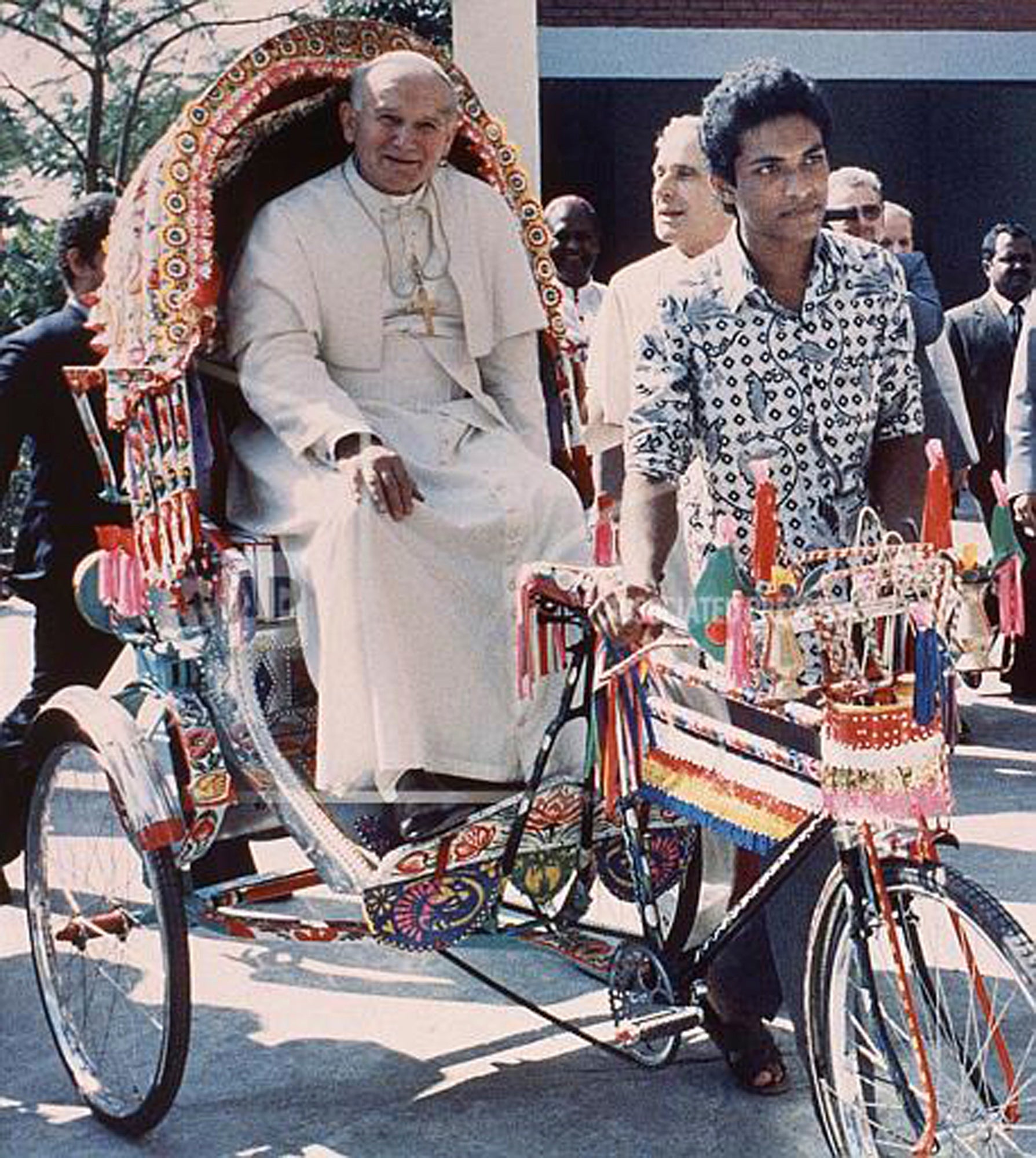 Pope John Paul II rides in a three-wheeled bicycle rickshaw at the Vatican Mission in Dhaka, Bangladesh, Nov. 19, 1986. (AP Photo/Arturo Mari, File)