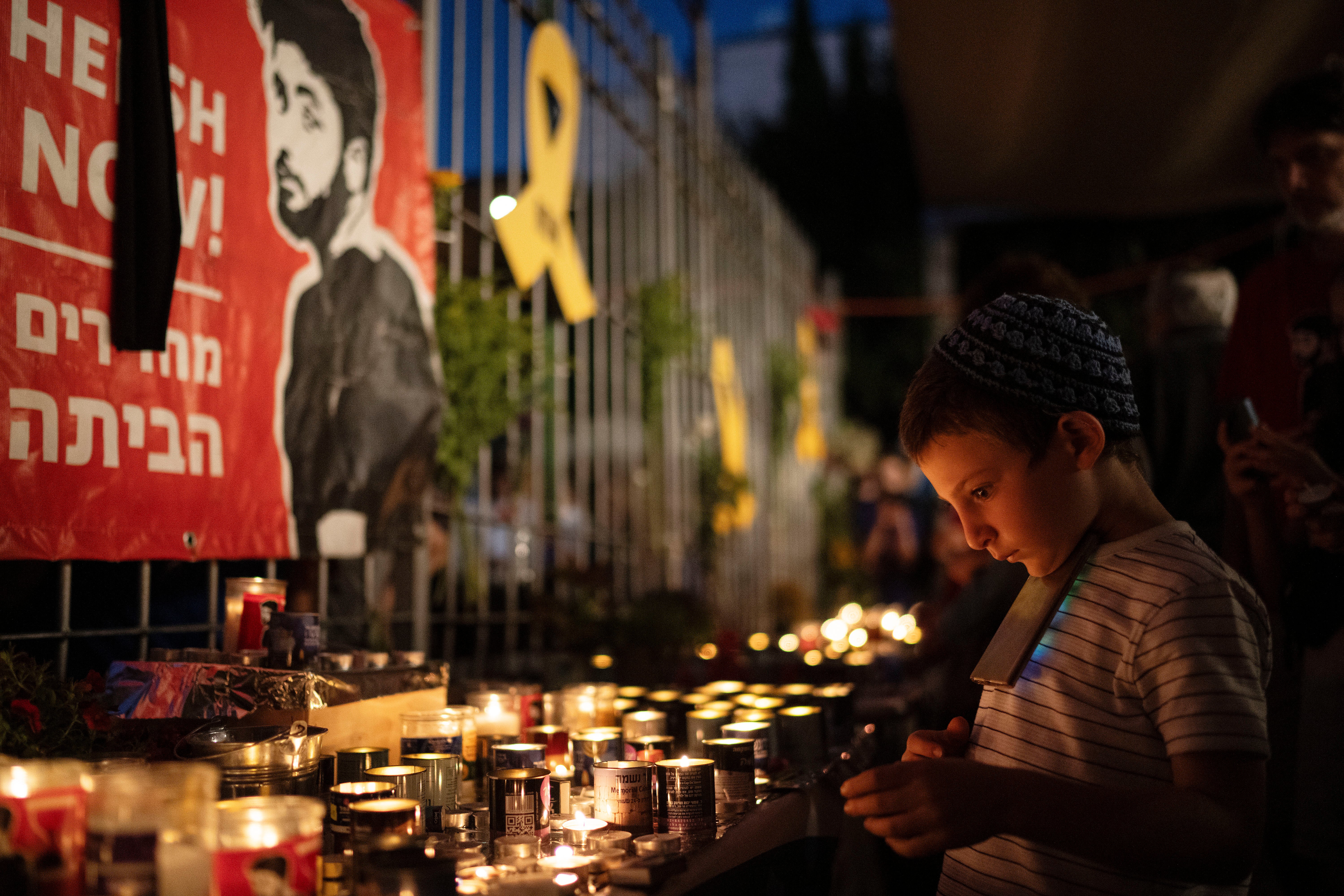 People in Jerusalem light candles during a vigil in memory of Hersh