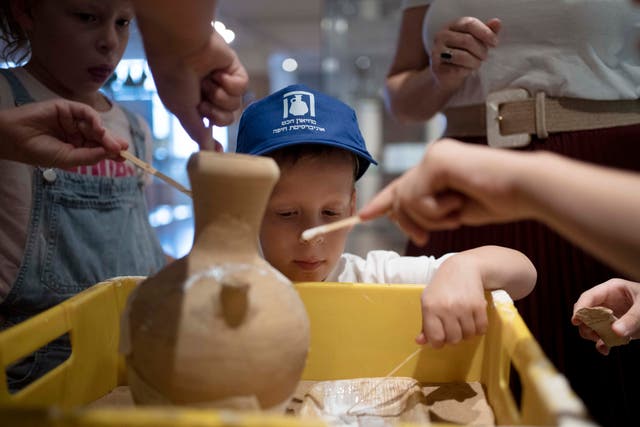 <p>Ariel Geller, 4, helps glue a broken clay jar during a special tour with his family at the Hecht Museum in Haifa, Israel</p>