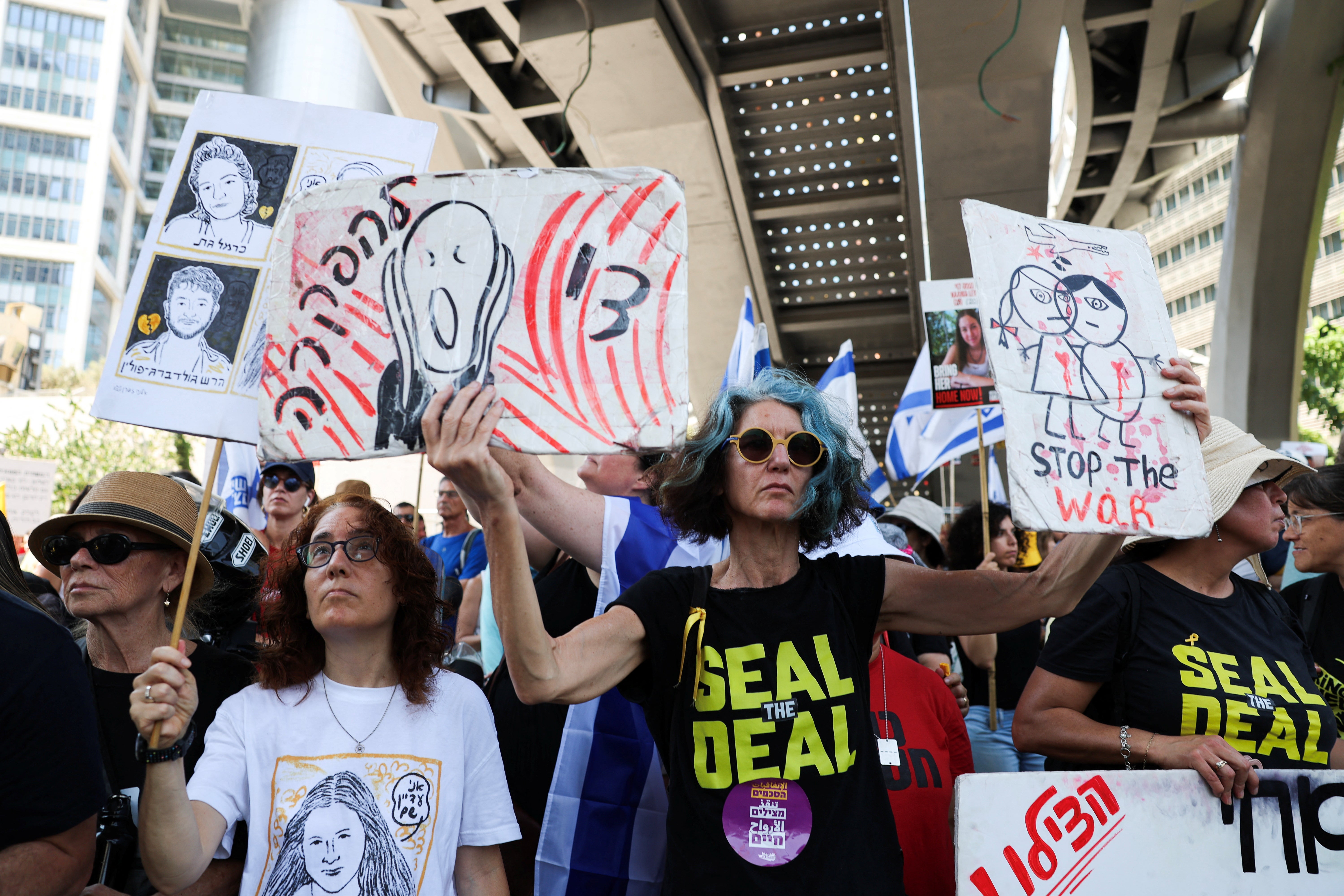 Demonstrators hold signs in protest near Israel’s defence ministry