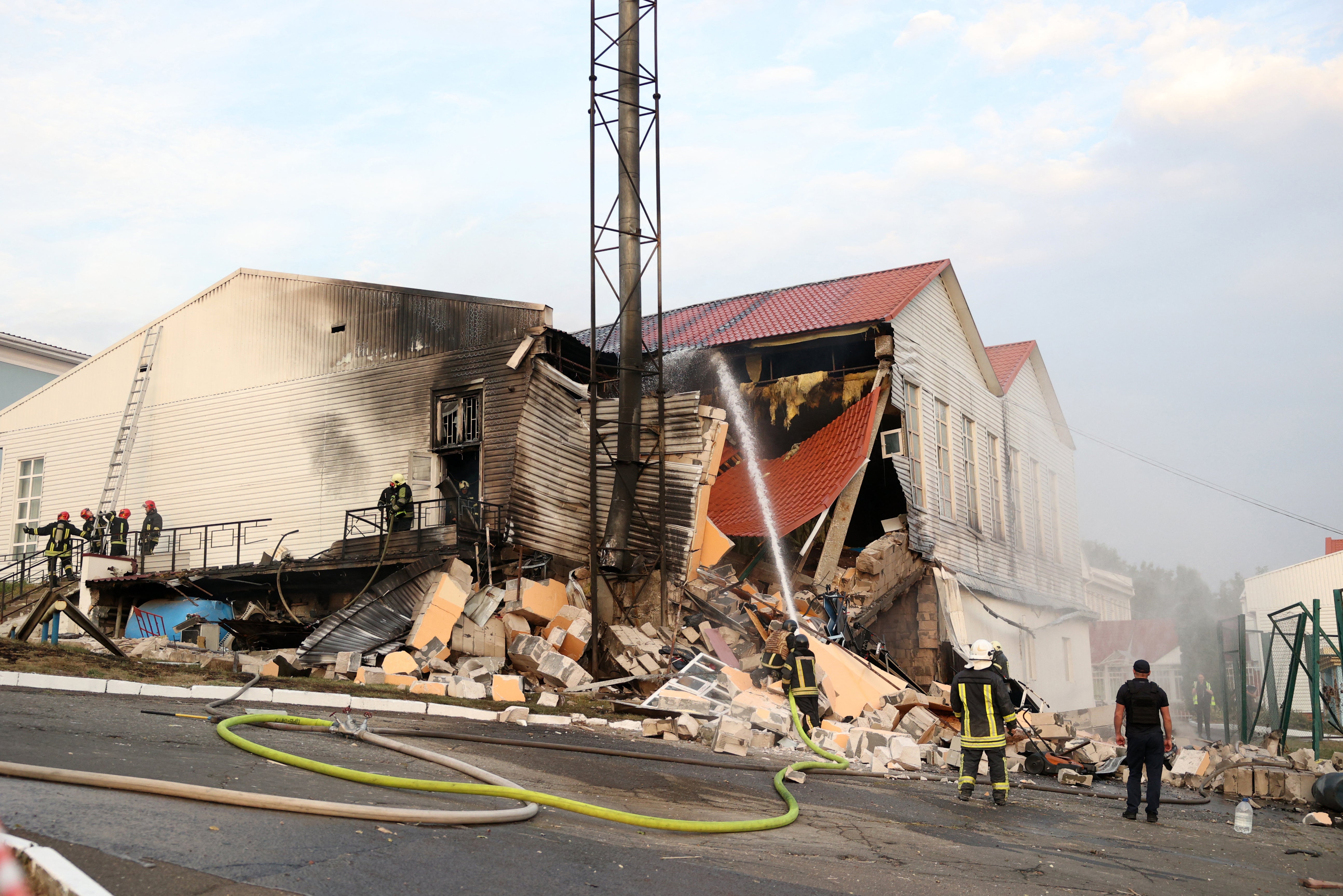 Firemen work to extinguish a fire after the latest missile attack on Kyiv