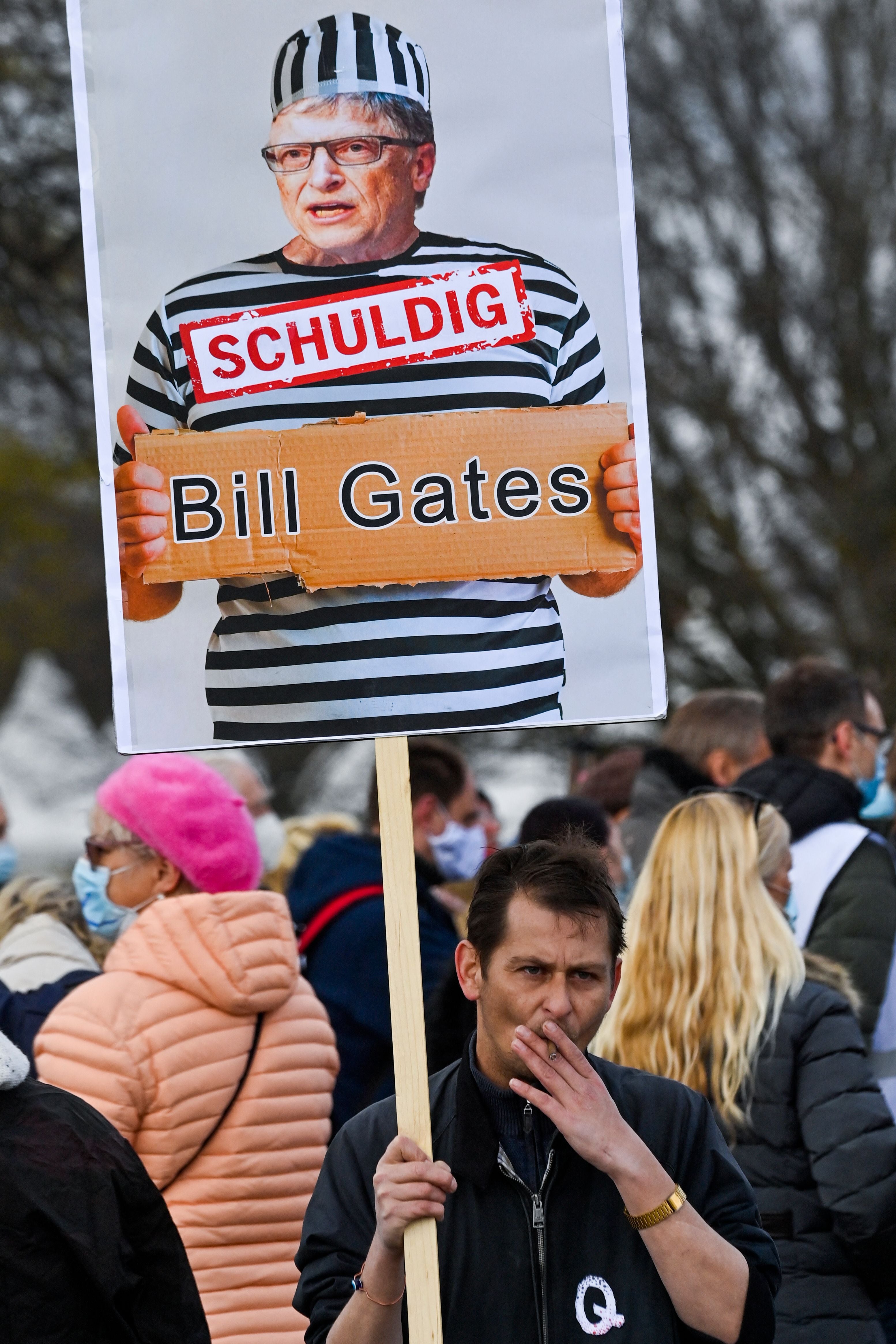 Um manifestante num comício anti-lockdown em Berlim, em abril de 2021, segura um cartaz com a imagem de Bill Gates e o slogan: ‘Culpado’