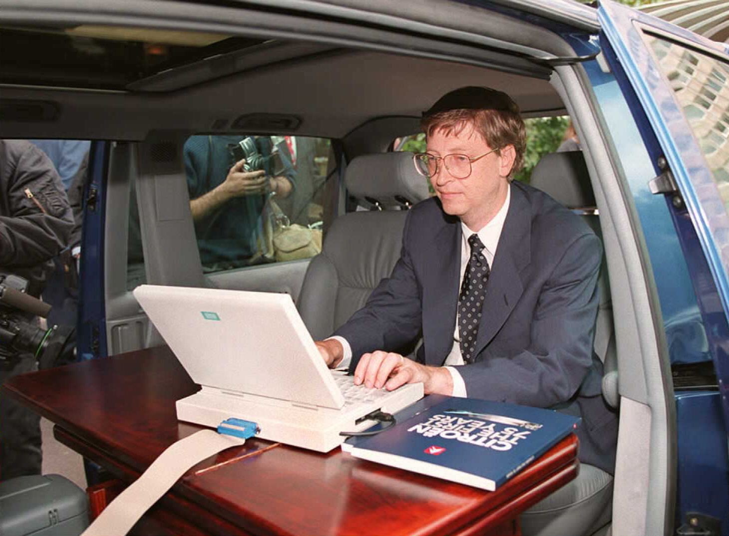 Bill Gates demonstrando o Windows 95 da Microsoft em seu carro antes de uma conferência de imprensa em Paris em setembro de 1995