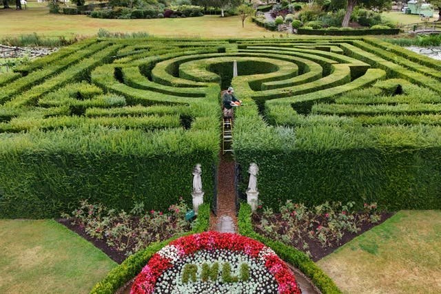 A gardener at Hever Castle tends to the bushes that makes up the120-year-old maze (Gareth Fuller/PA)