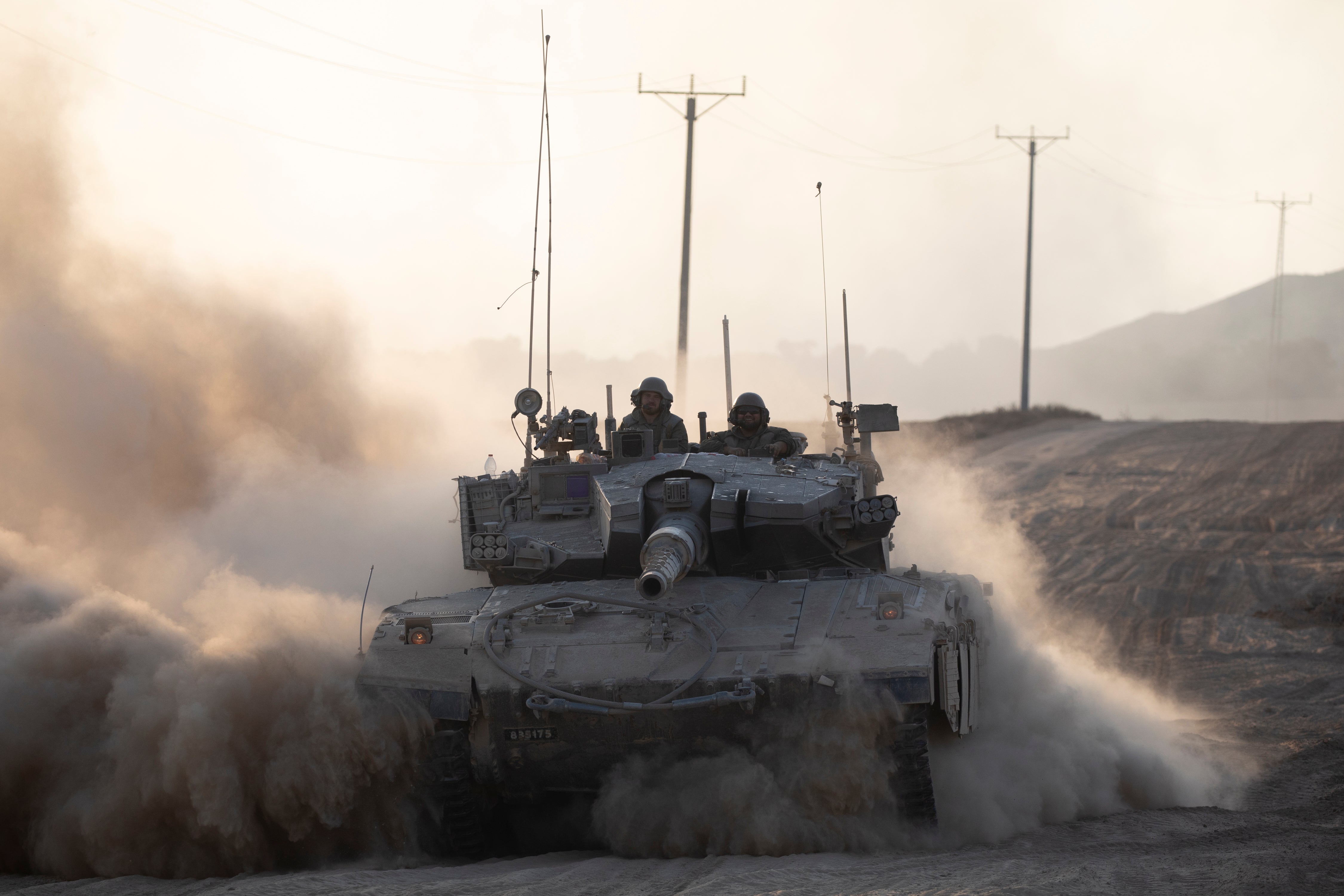 Israeli soldiers in a tank as it drives along the border with the Gaza Strip on August 7, 2024 in Southern Israel, Israel