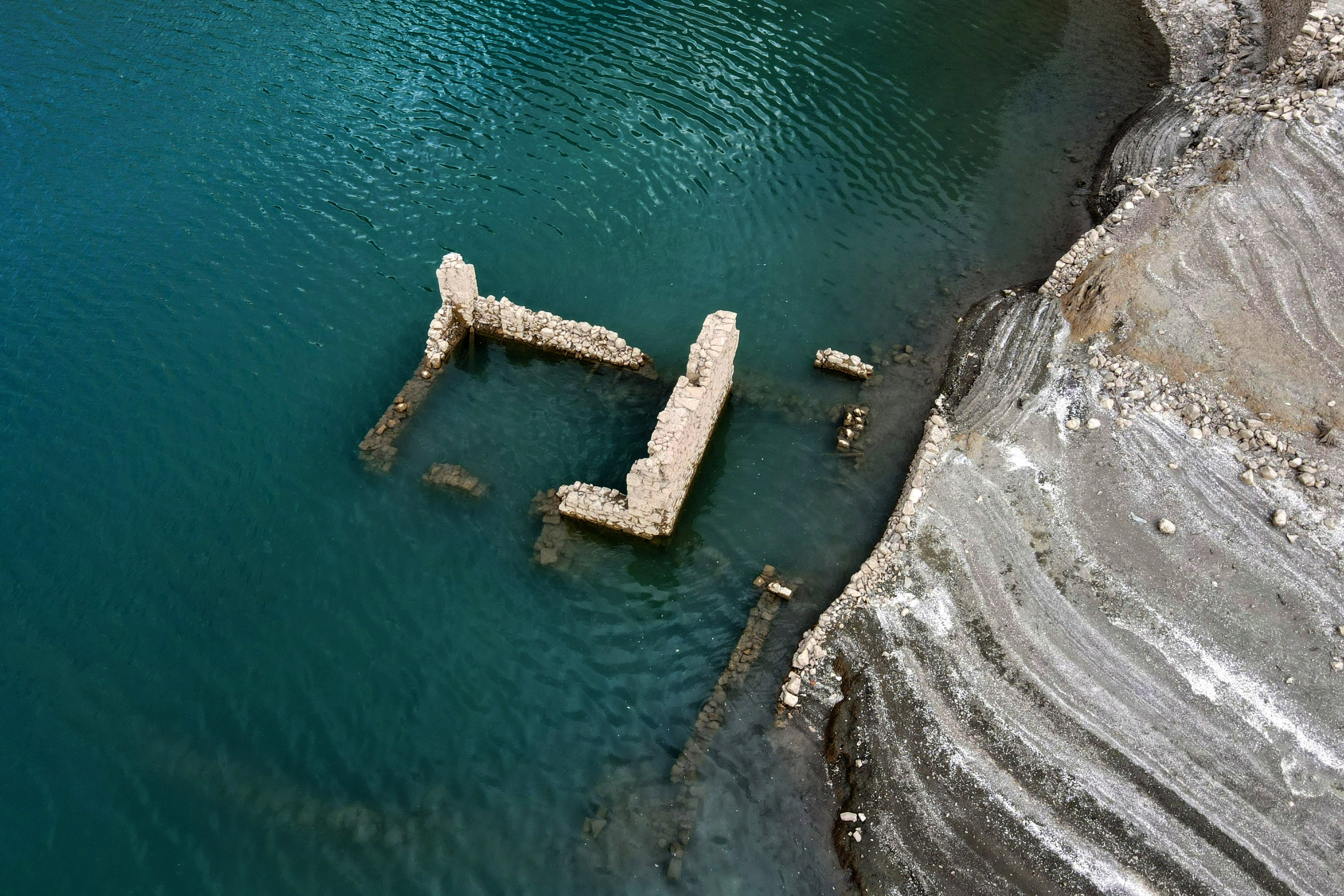 Os restos de um edifício da aldeia submersa de Kallio são revelados devido ao recuo do nível da água do lago artificial de Mornos, perto da aldeia de Lidoriki