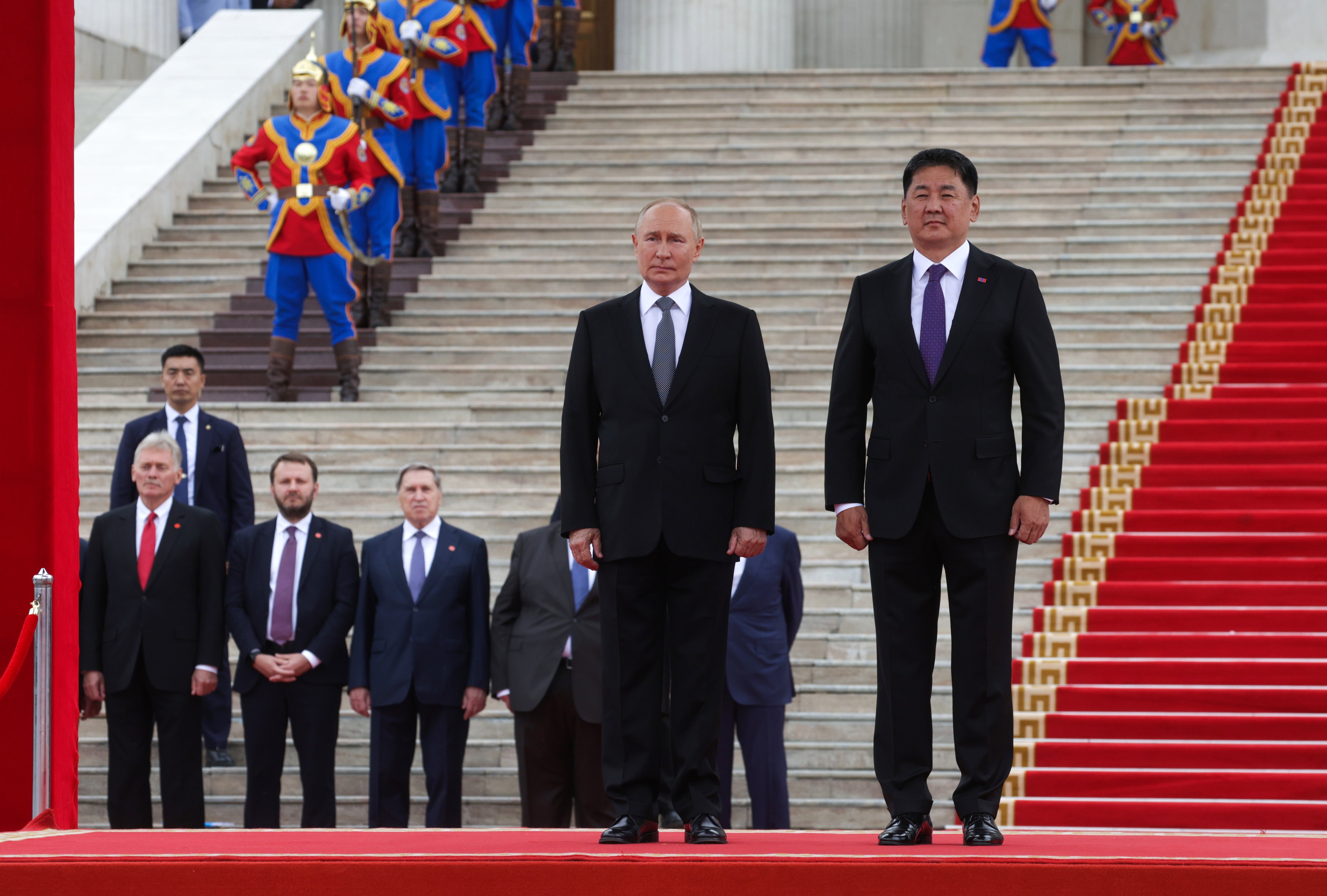 Russian president Vladimir Putin (C) and Mongolian president Ukhnaagiin Khurelsukh (R) attend a welcome ceremony in Sukhbaatar Square in Ulaanbaatar, Mongolia