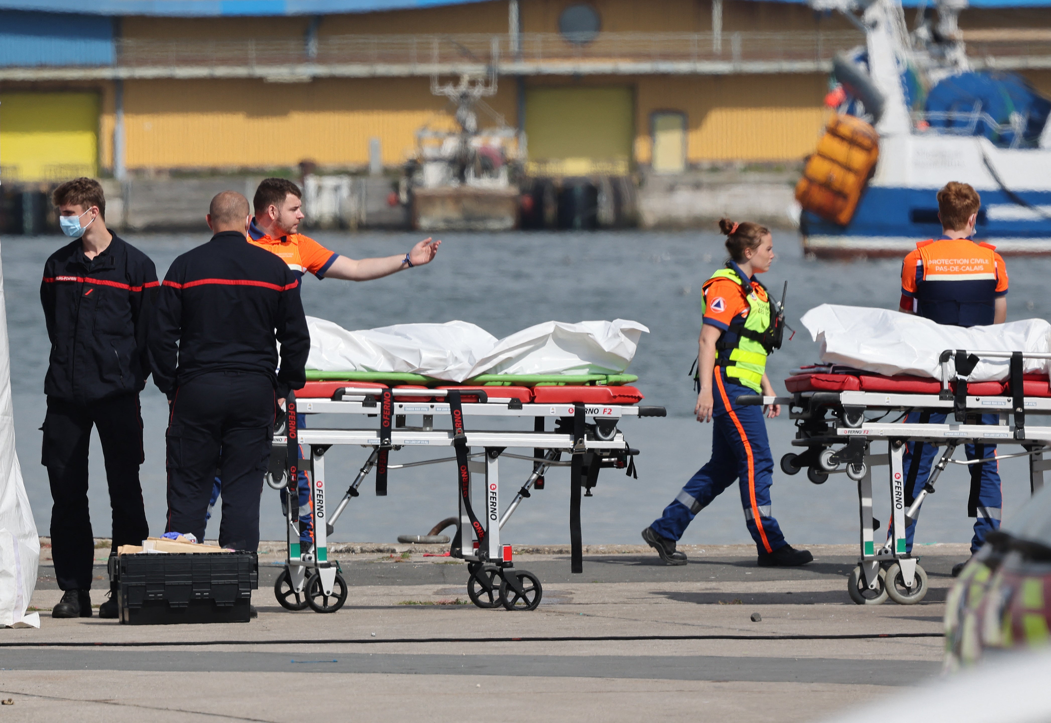 The bodies of people who died attempting to cross the Channel are brought ashore in Boulogne-sur-Mer, northern France, on Tuesday