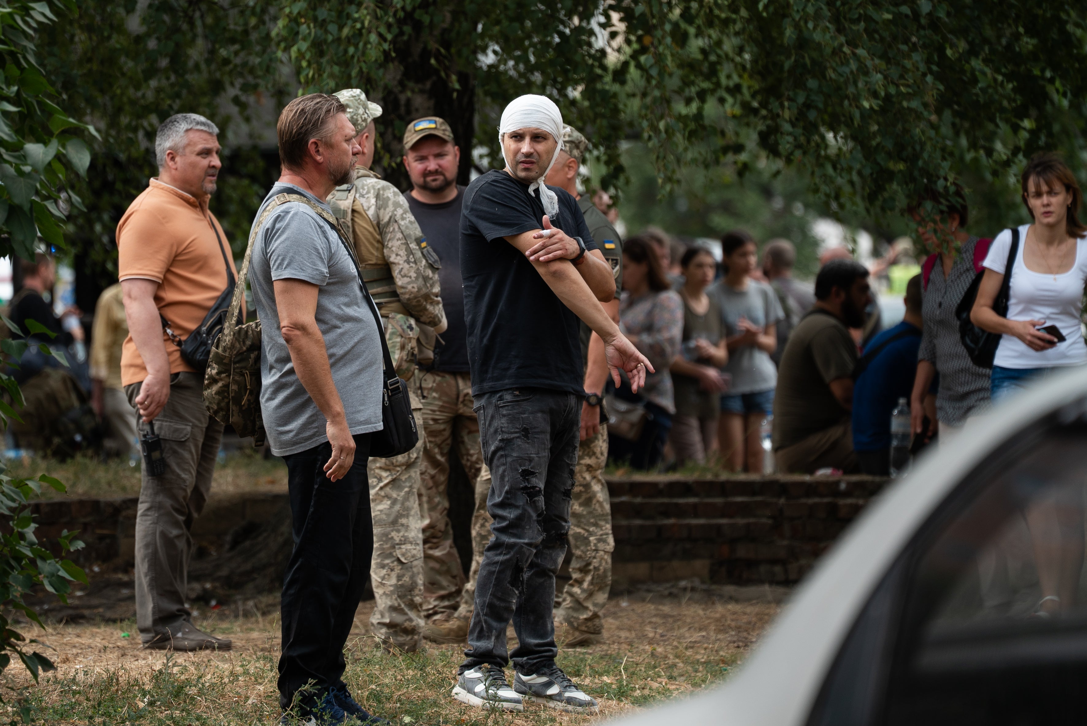 People stand in the street near the Poltava Military Institute of Communications after a Russian missile attack in Poltava, Ukraine