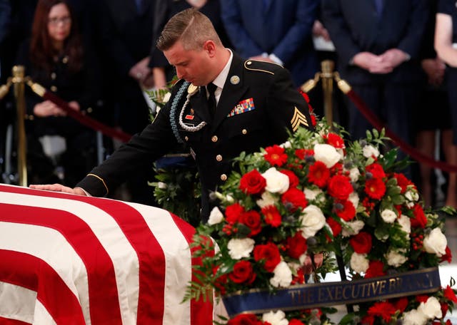 <p>Jimmy McCain, son of late U.S. Senator John McCain, touches his father's casket during ceremonies honoring the late US Senator John McCain inside the Rotunda of the U.S. Capitol, August 31, 2018. Now, he is blasting Donald Trump over the Republican nominee’s visit to Arlington. </p>