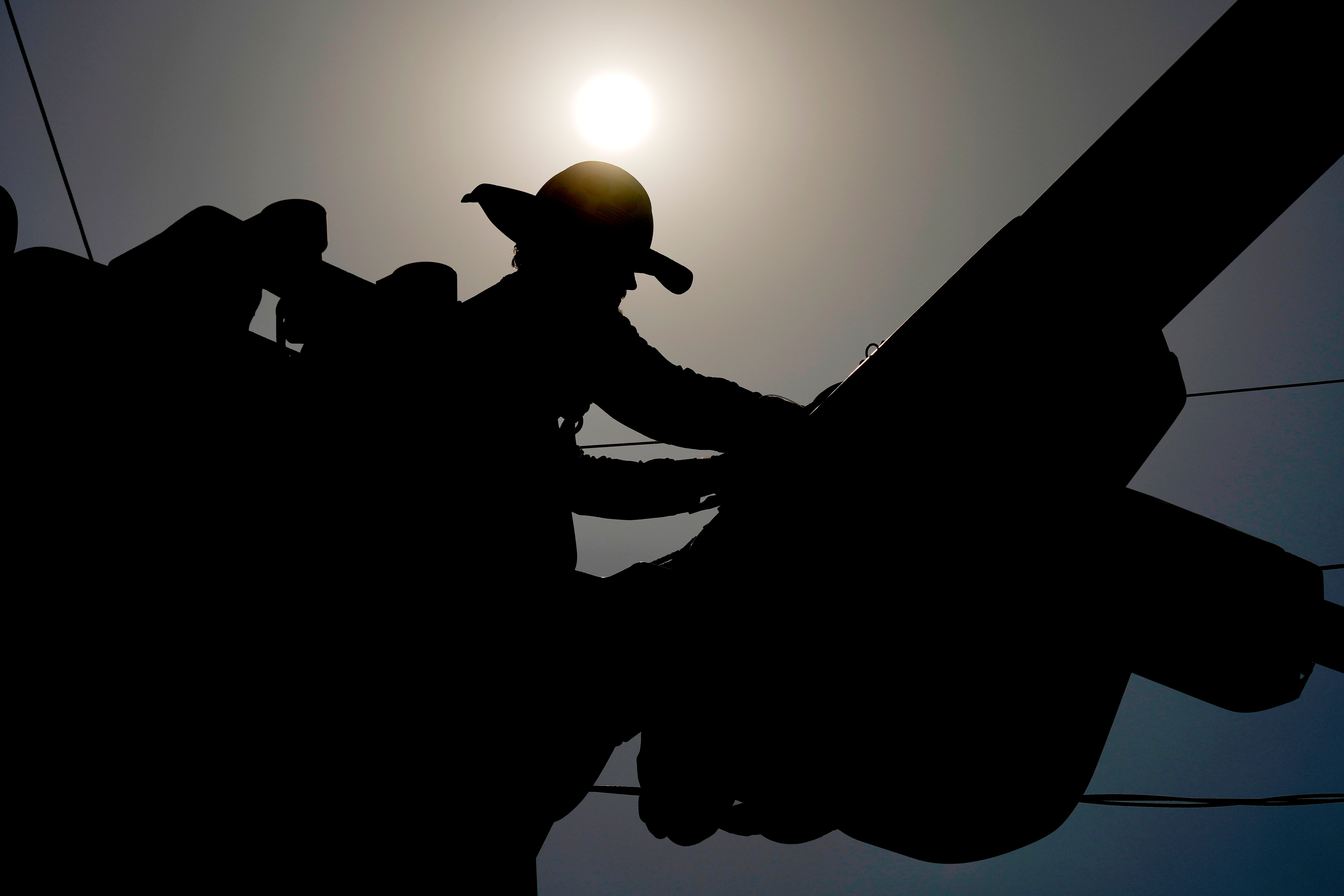 A linesman works on power lines under the Phoenix sun this July. Arizona’s capital has seen 100 days of sweltering 100-degree temperatures since May 27, according to the National Weather Service. The last record, in 1993, was 76 days. The city is not expected to have relief any time soon, with another week of triple-digit temperatures forecast.