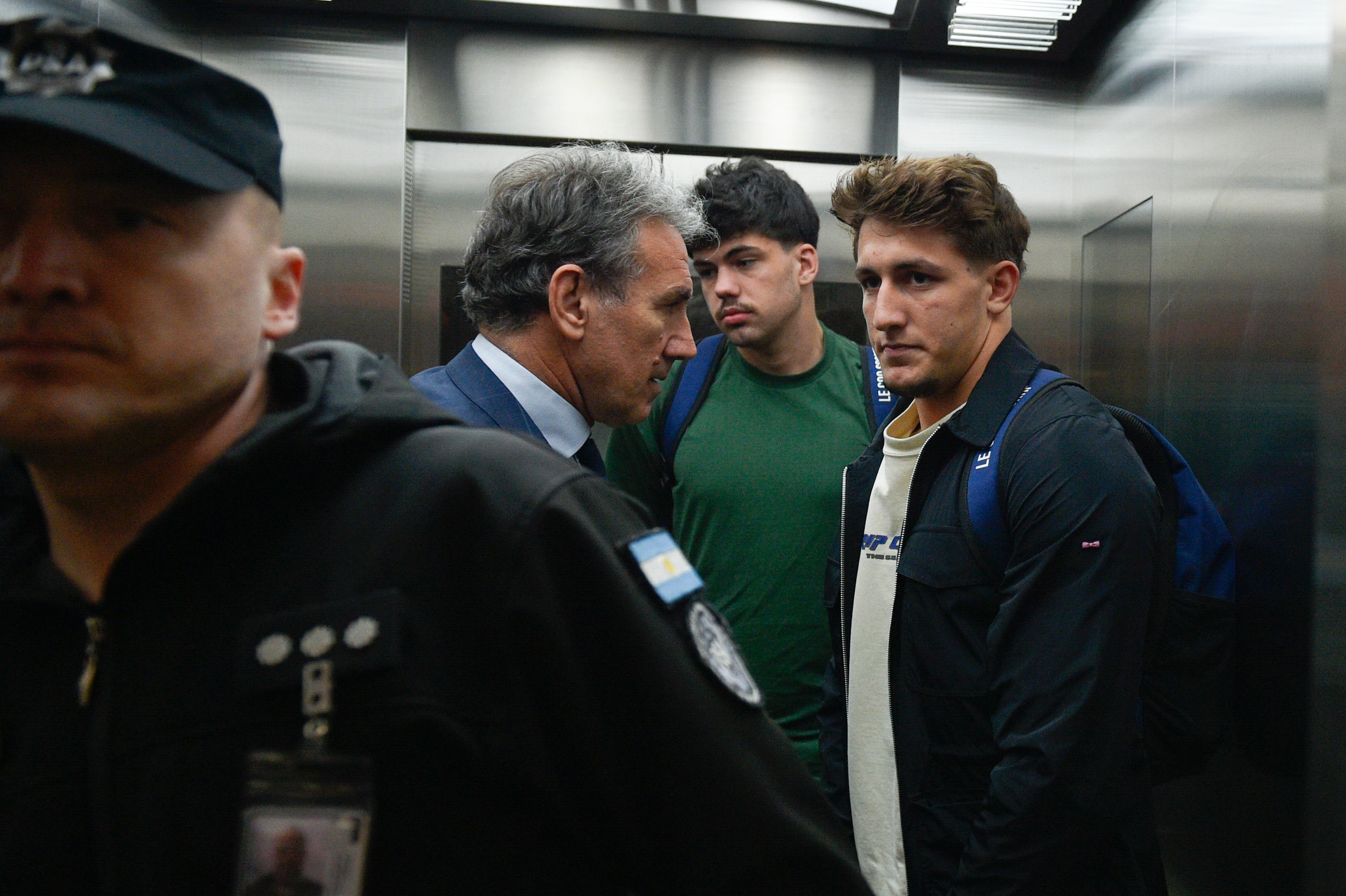 Jegou and Auradou stand next to their lawyer Rafael Cuneo Libarona at the airport