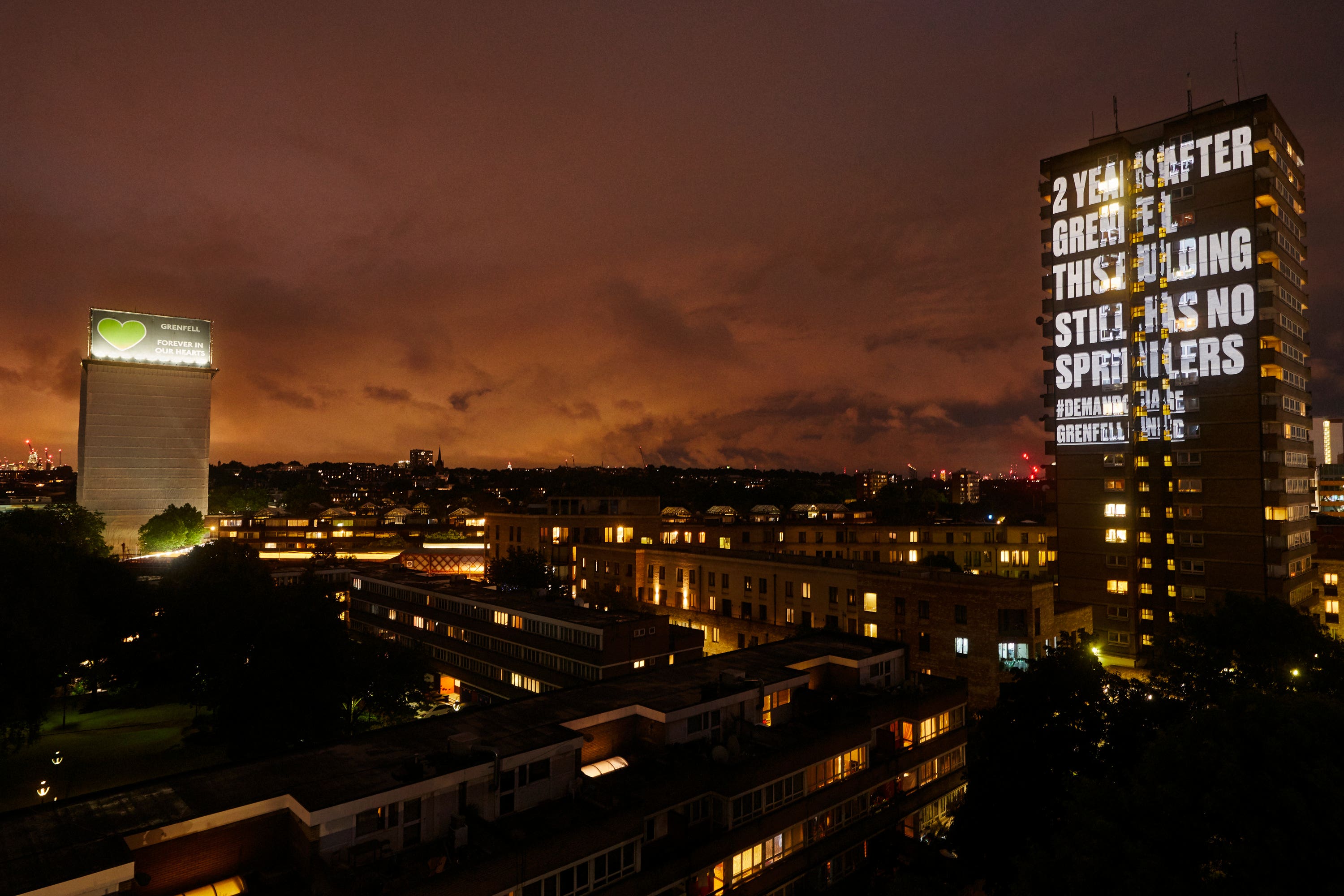 A message demanding change projected on to a building in London near to Grenfell Tower (Grenfell United/PA)