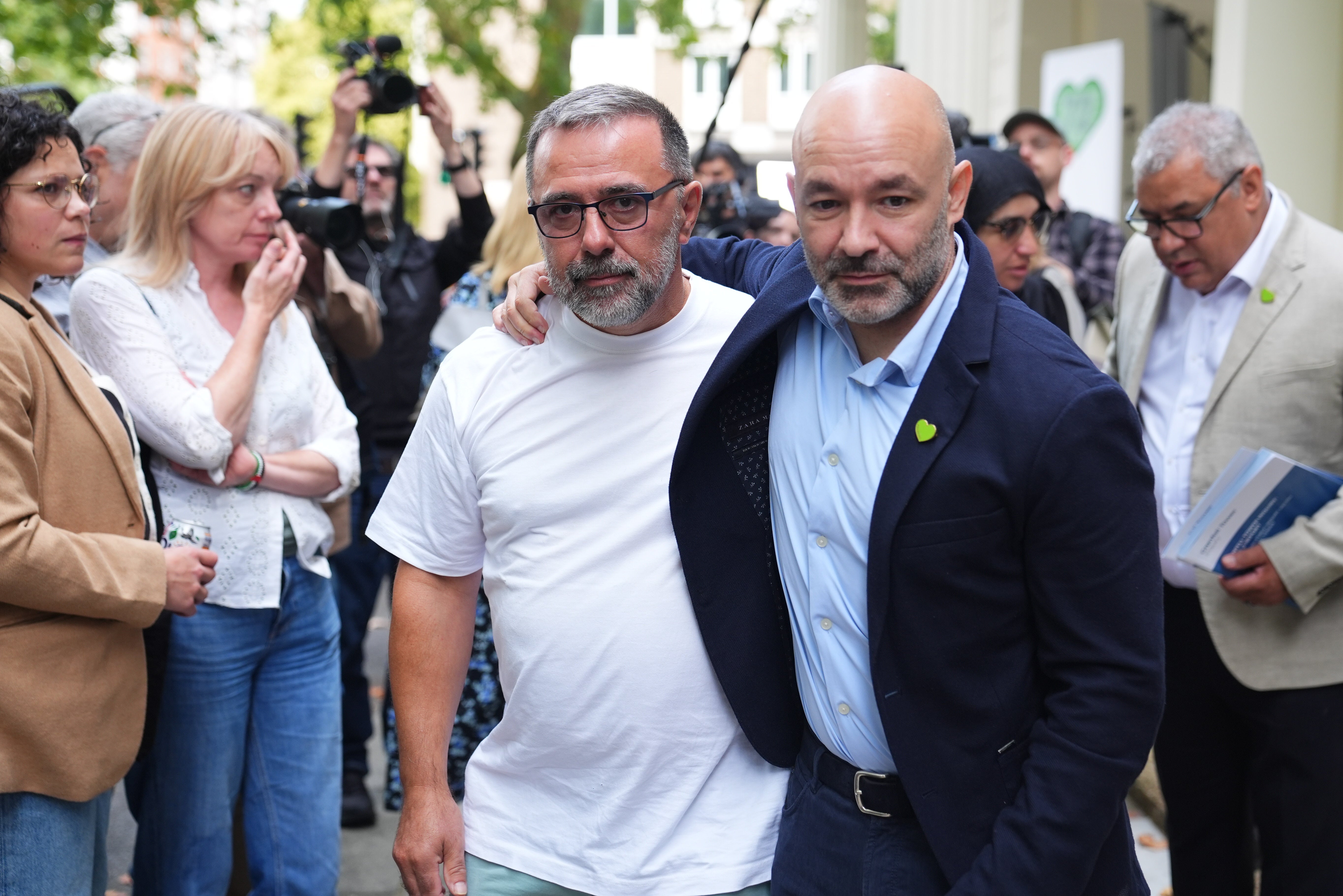 Marcio Gomes of Grenfell United (right) leaves Dorland House in London with survivors and bereaved families