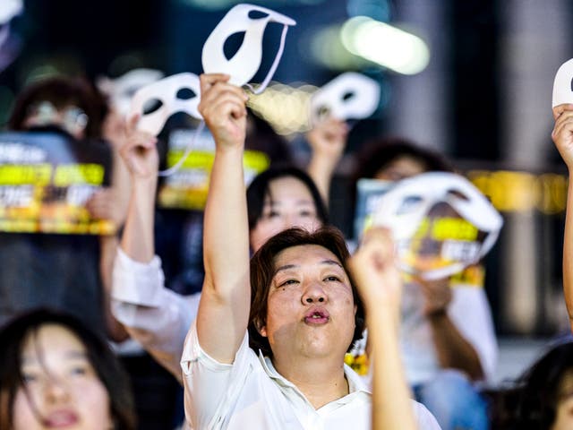 <p>File: Activists shout slogans and hold eye masks during a protest against deepfake porn in Seoul on 30 August 2024</p>