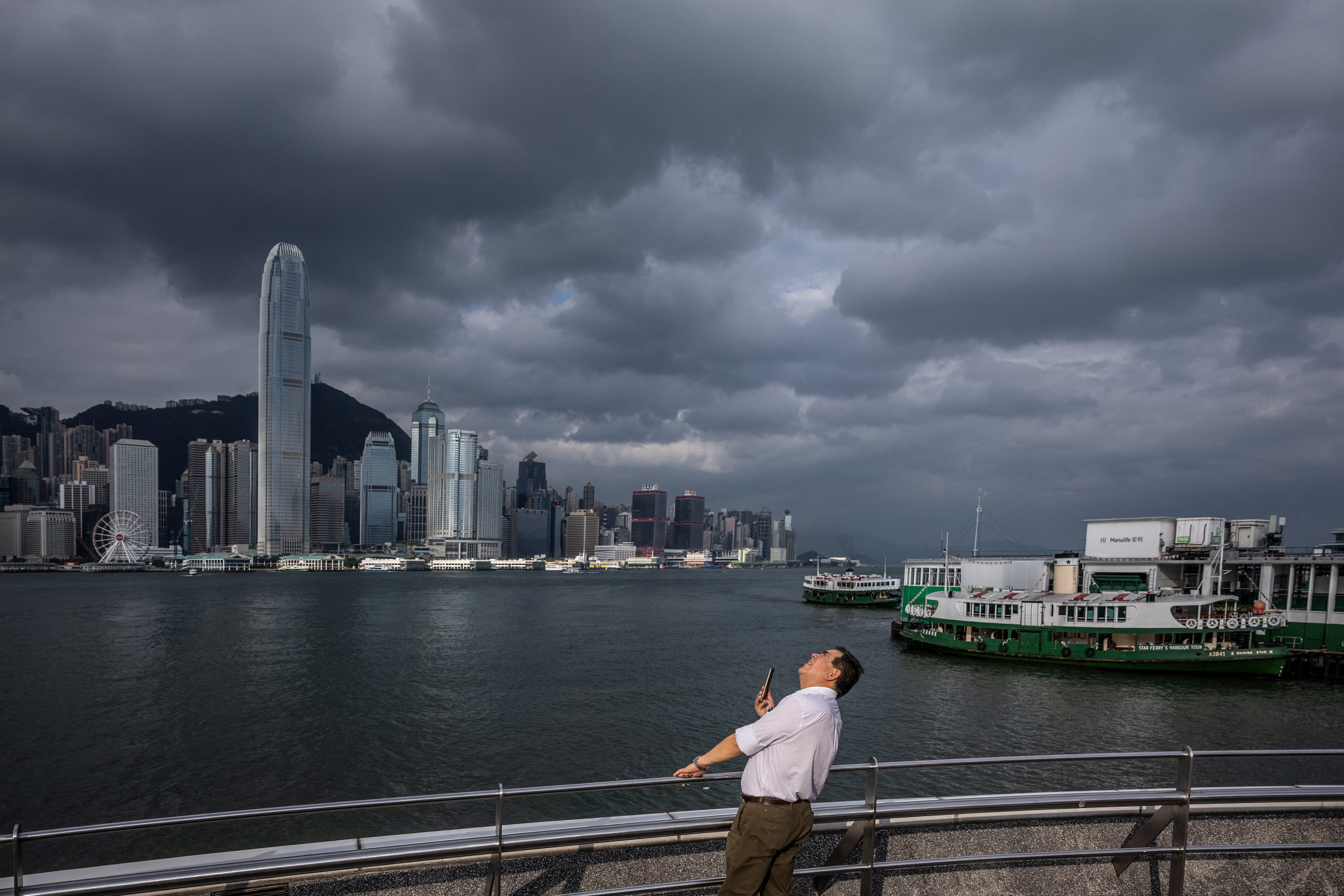 A man watches Super Typhoon Yagi move across the South China Sea toward China's southern coast on Hong Kong's Victoria Harbour Promenade on Thursday.