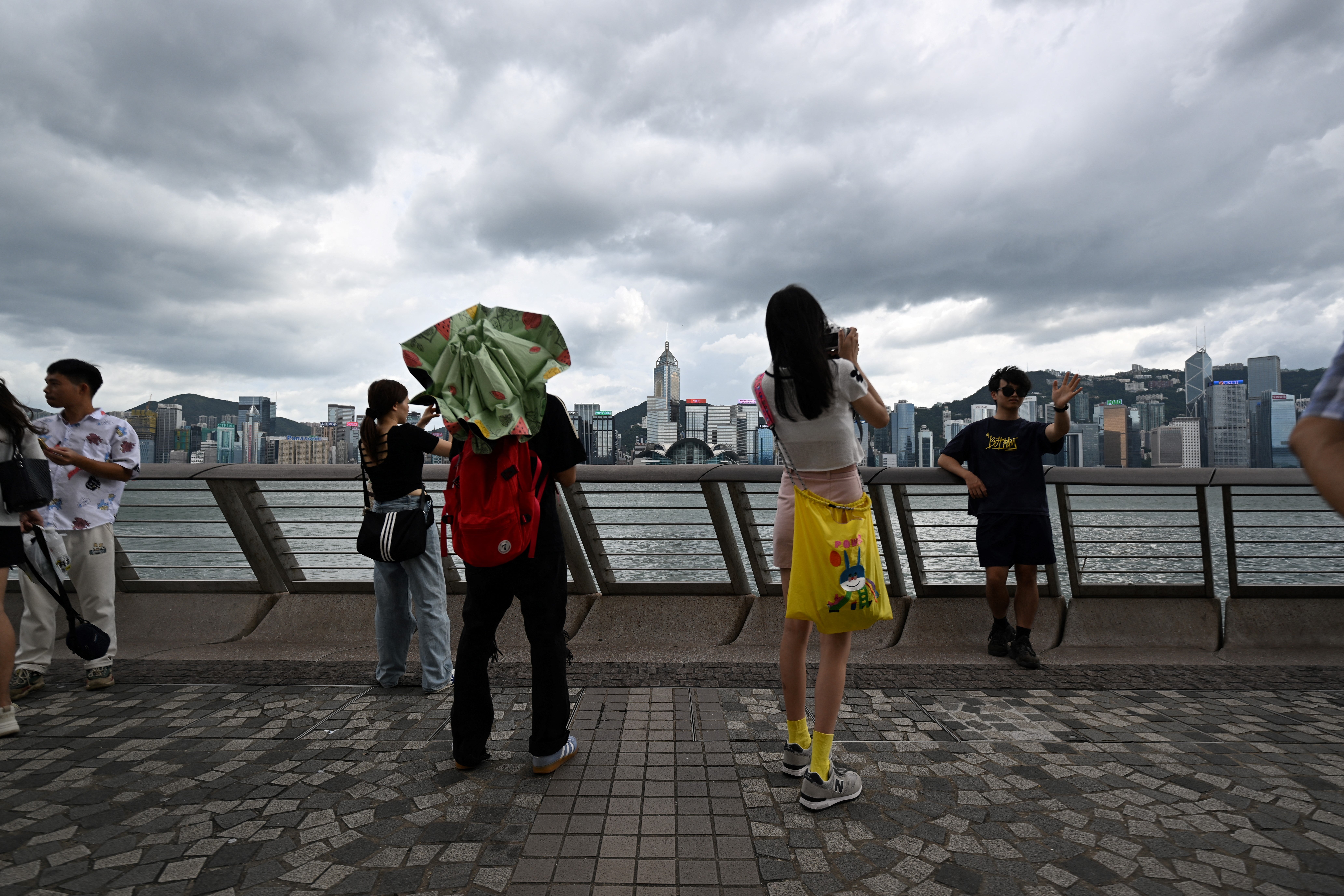 Tourists take photos on the Victoria Harbour promenade in Hong Kong on Thursday as Super Typhoon Yagi moves across the South China Sea toward China's southern coast.