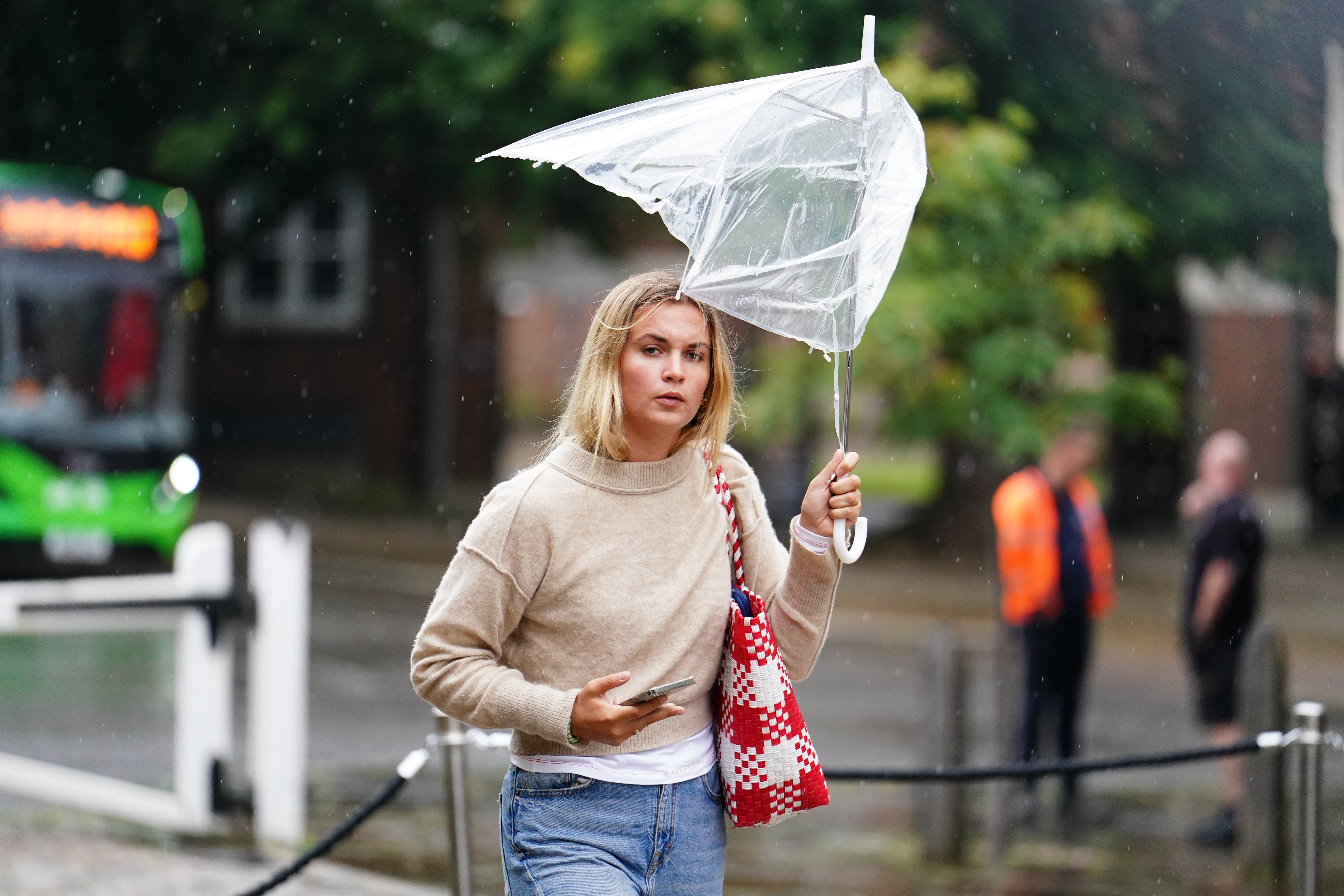 A woman battles with her umbrella as autumnal weather takes hold early on