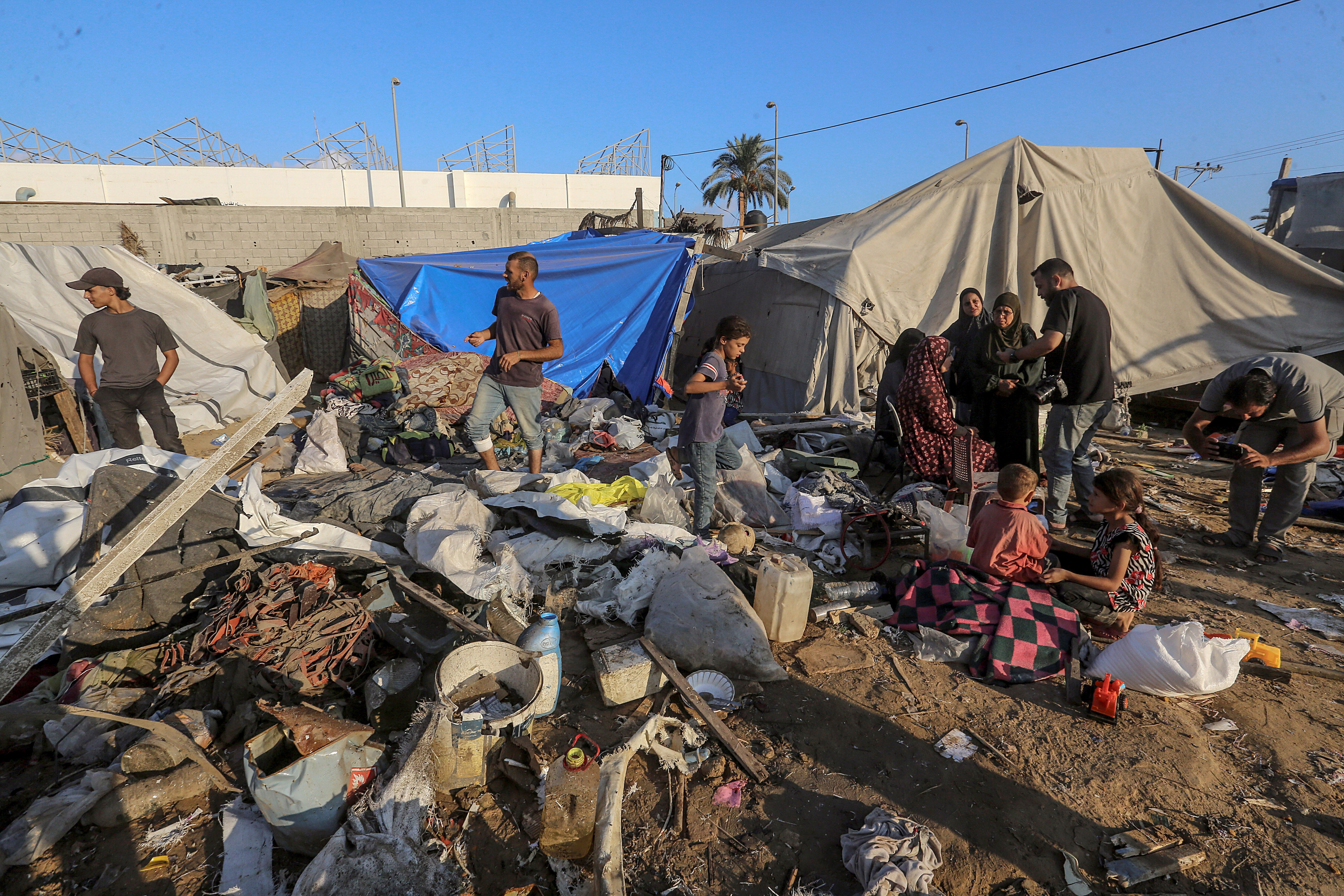 Internally displaced Palestinians inspect their destroyed shelters following Deir Al Balah military strike