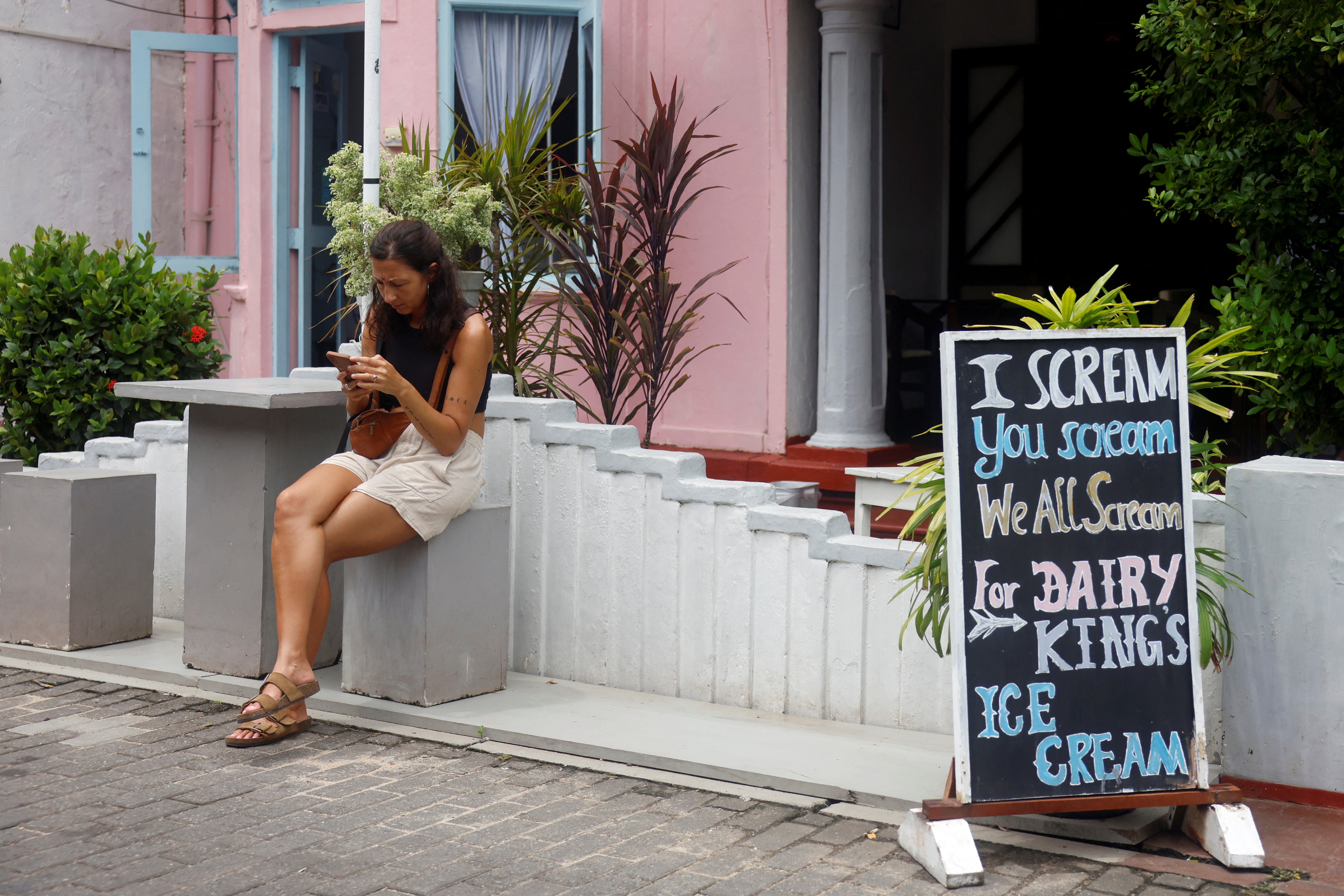 A foreigner sits outside the Diary King home-made ice cream shop, in Galle, Sri Lanka August 17, 2024