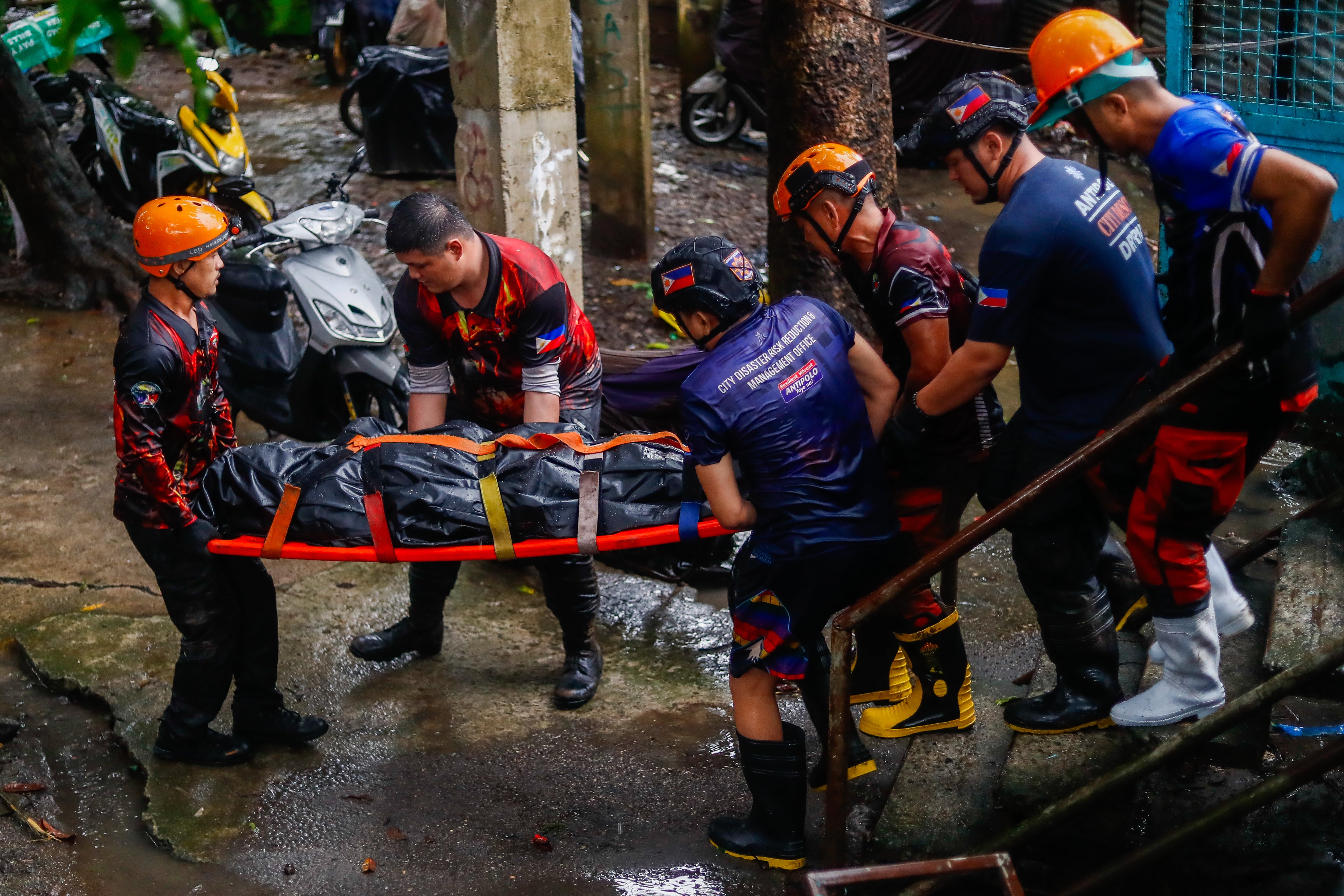 Rescuers carry the body of a resident who was found dead following a flooding that crushed a house, after Typhoon Yagi (Enteng) bringing heavy rains and strong winds hit the country, in the mountainous area of Antipolo, Rizal, The Philippines, on Tuesday