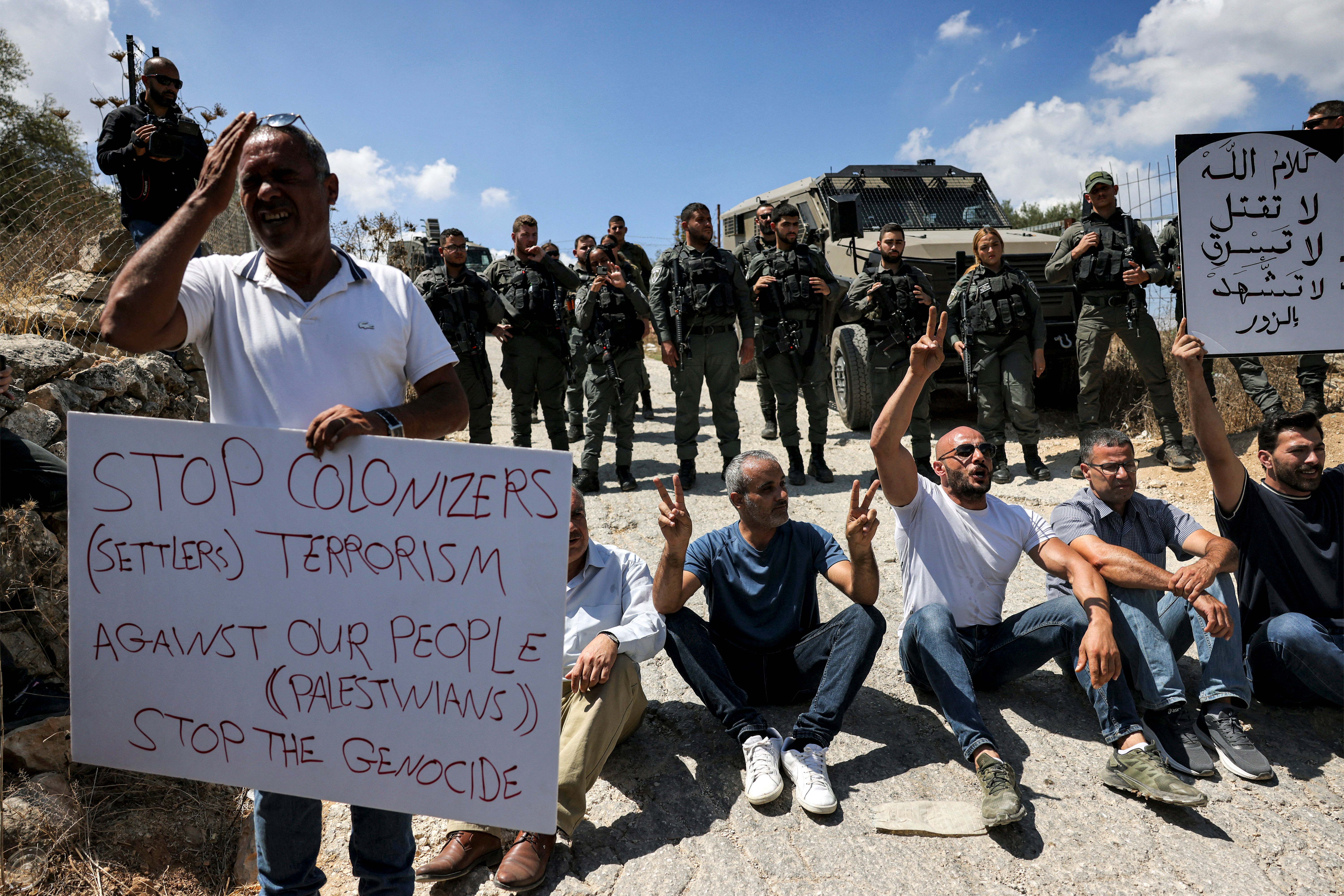 Manifestantes sentaram-se diante dos guardas de fronteira israelenses durante uma vigília de protesto em Beit Jala, na Cisjordânia ocupada, esta semana