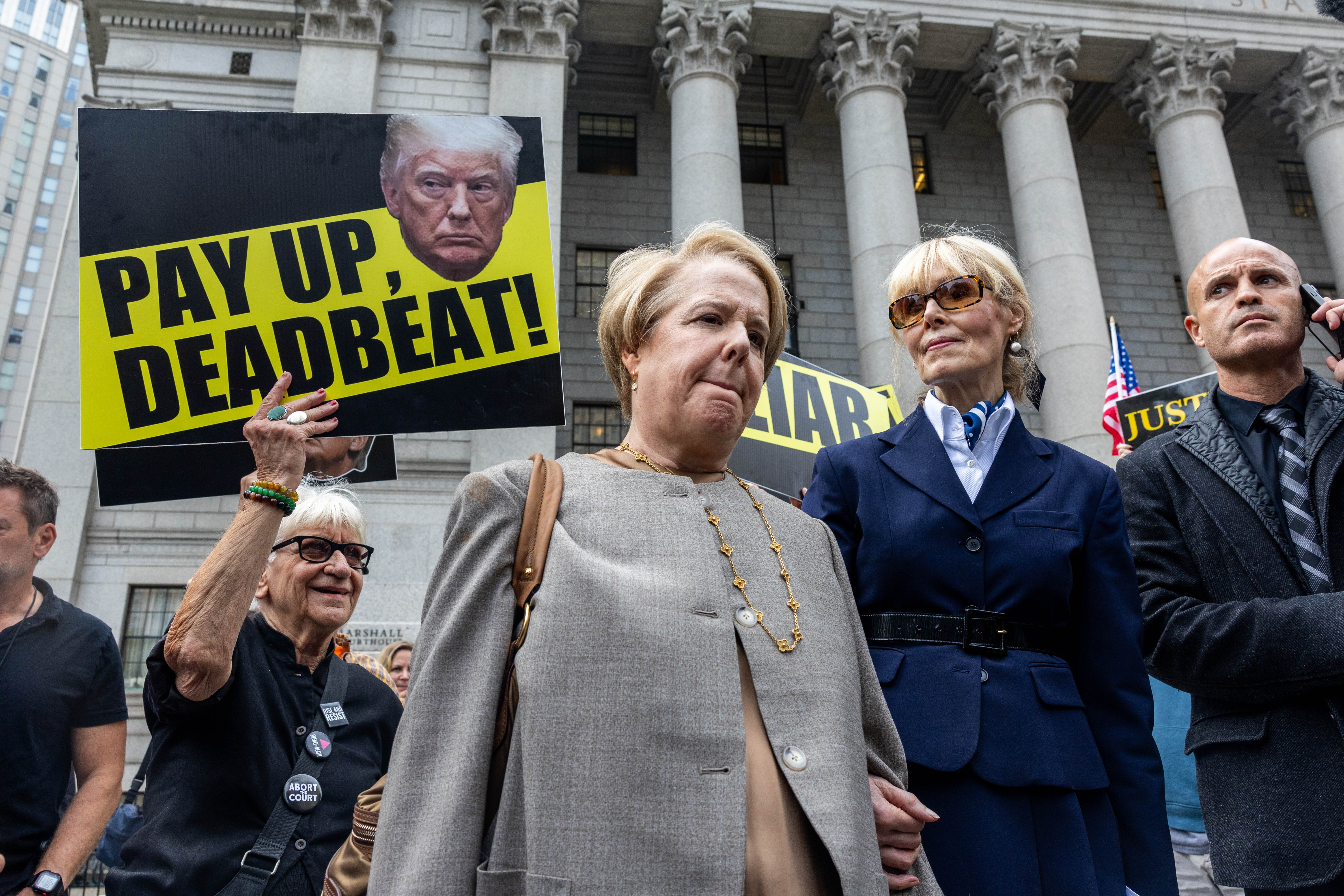 Protesters surround E Jean Carroll and her attorney Roberta Kaplan as they leave a federal courthouse on September 6 following an appeals court hearing in a defamation case against Donald Trump