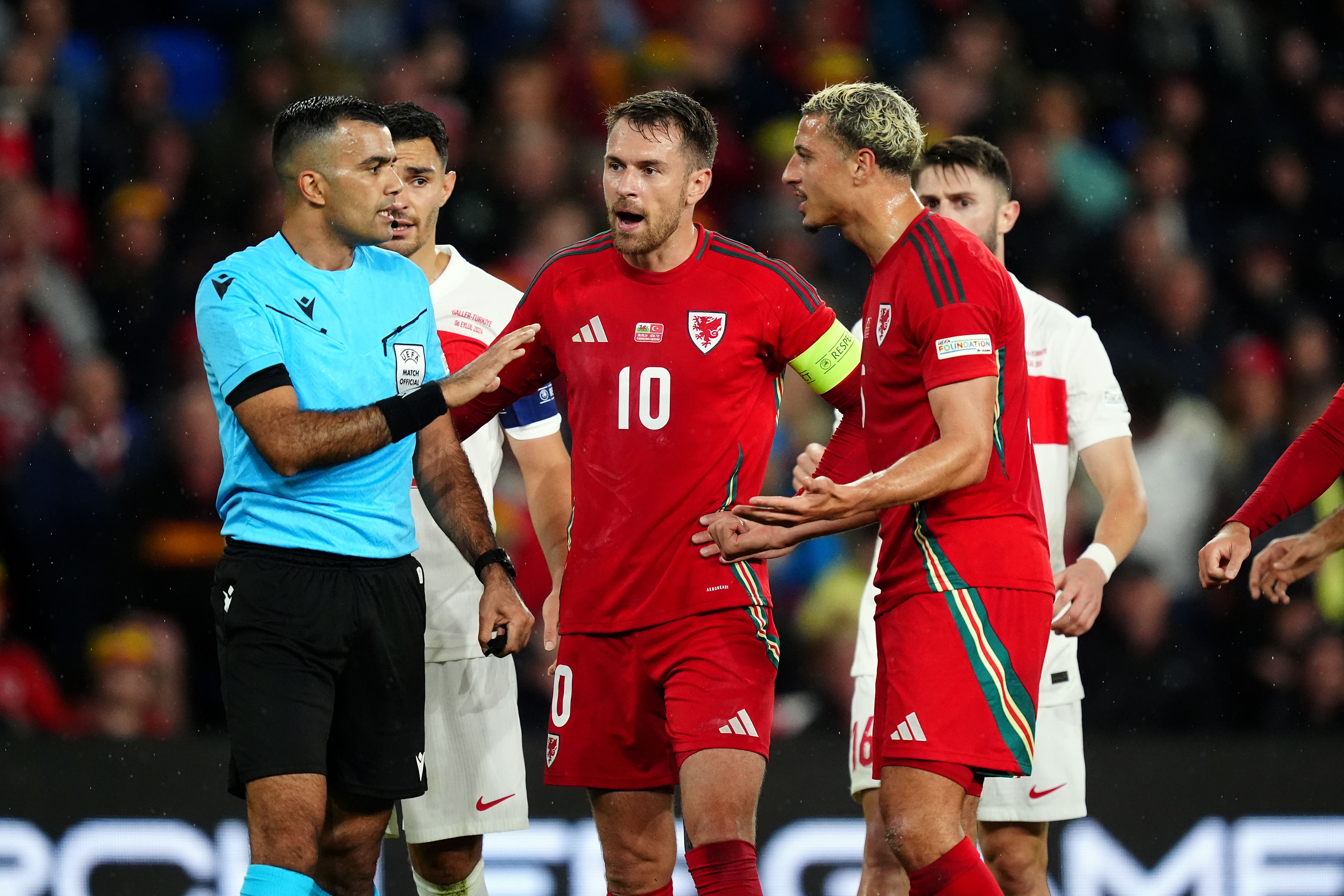 Referee Rohit Saggi speaks to Wales pair Aaron Ramsey and Ethan Ampadu in the goalless Nations League draw with Turkey (David Davies/PA)