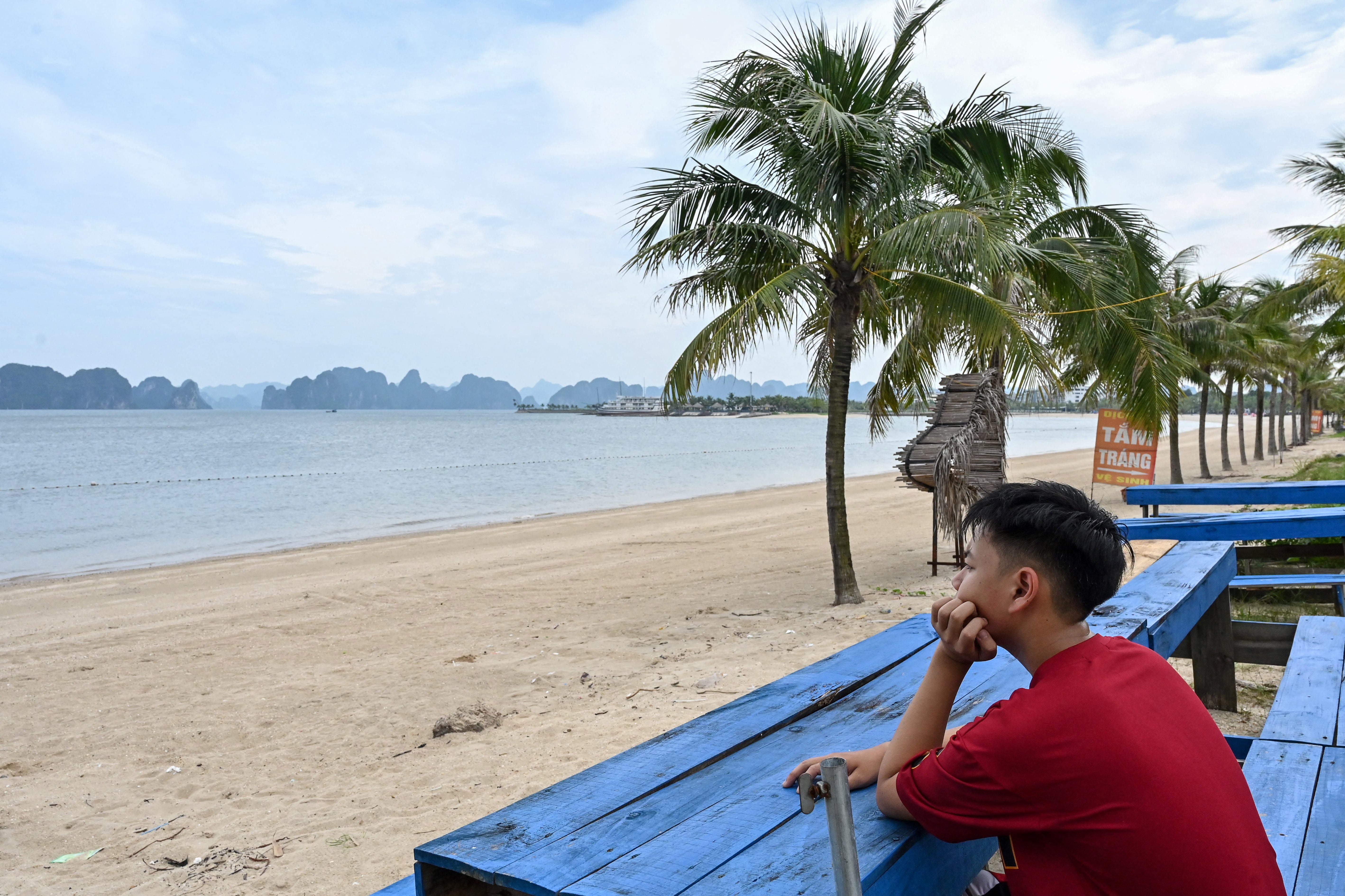 A man sits in a bar overlooking Ha Long Bay ahead of the approaching Typhoon Yagi in Quang Ninh province on 6 September 2024