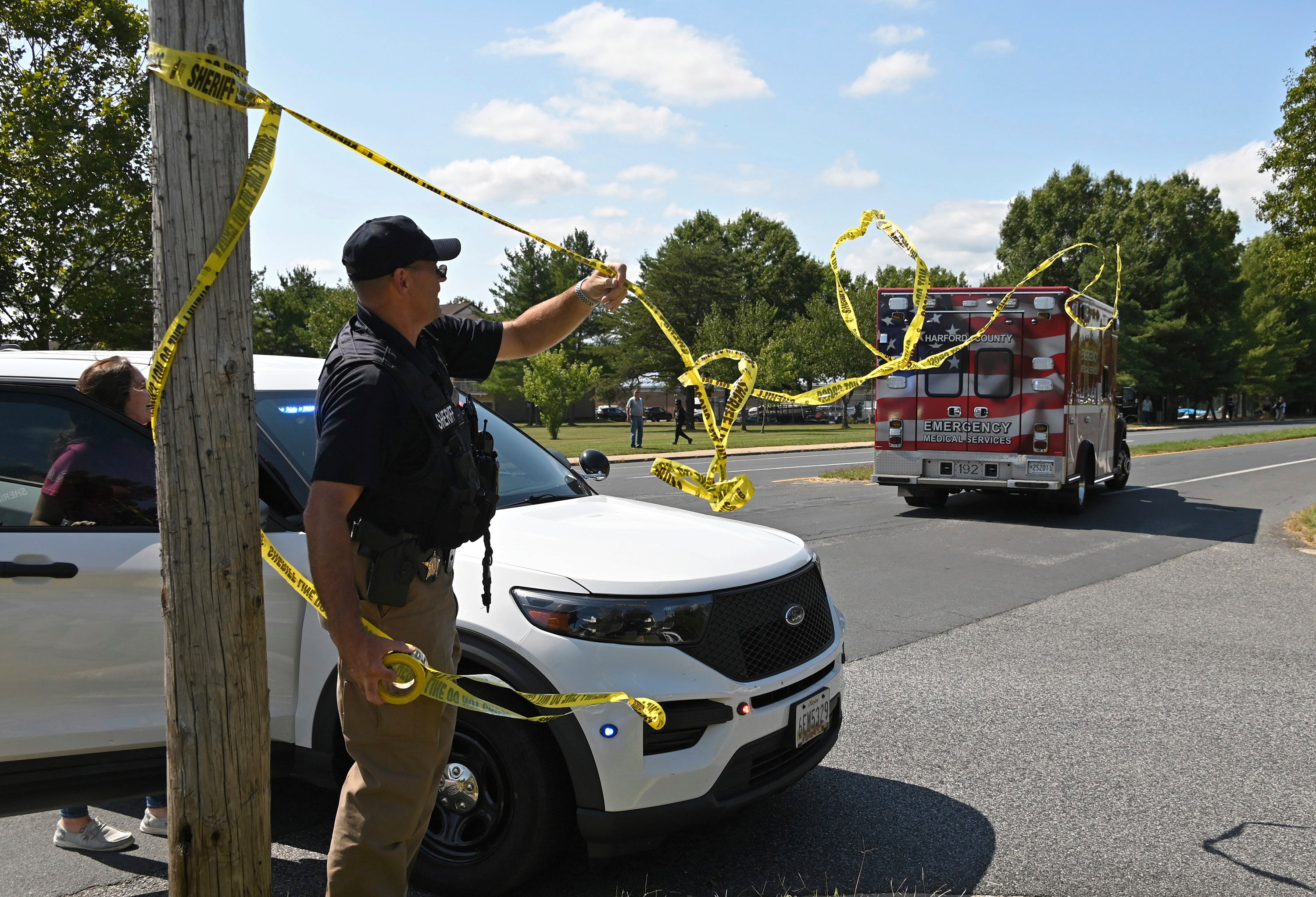 A member of the Harford County Sheriff's department tries to clear the way for an emergency vehicle as it heads toward Joppatowne High School after a shooting at the school, Friday, Sept. 6, 2024, in Joppatowne, Md