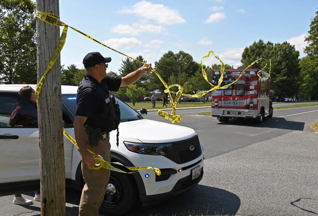 <p>A member of the Harford County Sheriff's department tries to clear the way for an emergency vehicle as it heads toward Joppatowne High School after a shooting at the school, Friday, Sept. 6, 2024, in Joppatowne, Md</p>