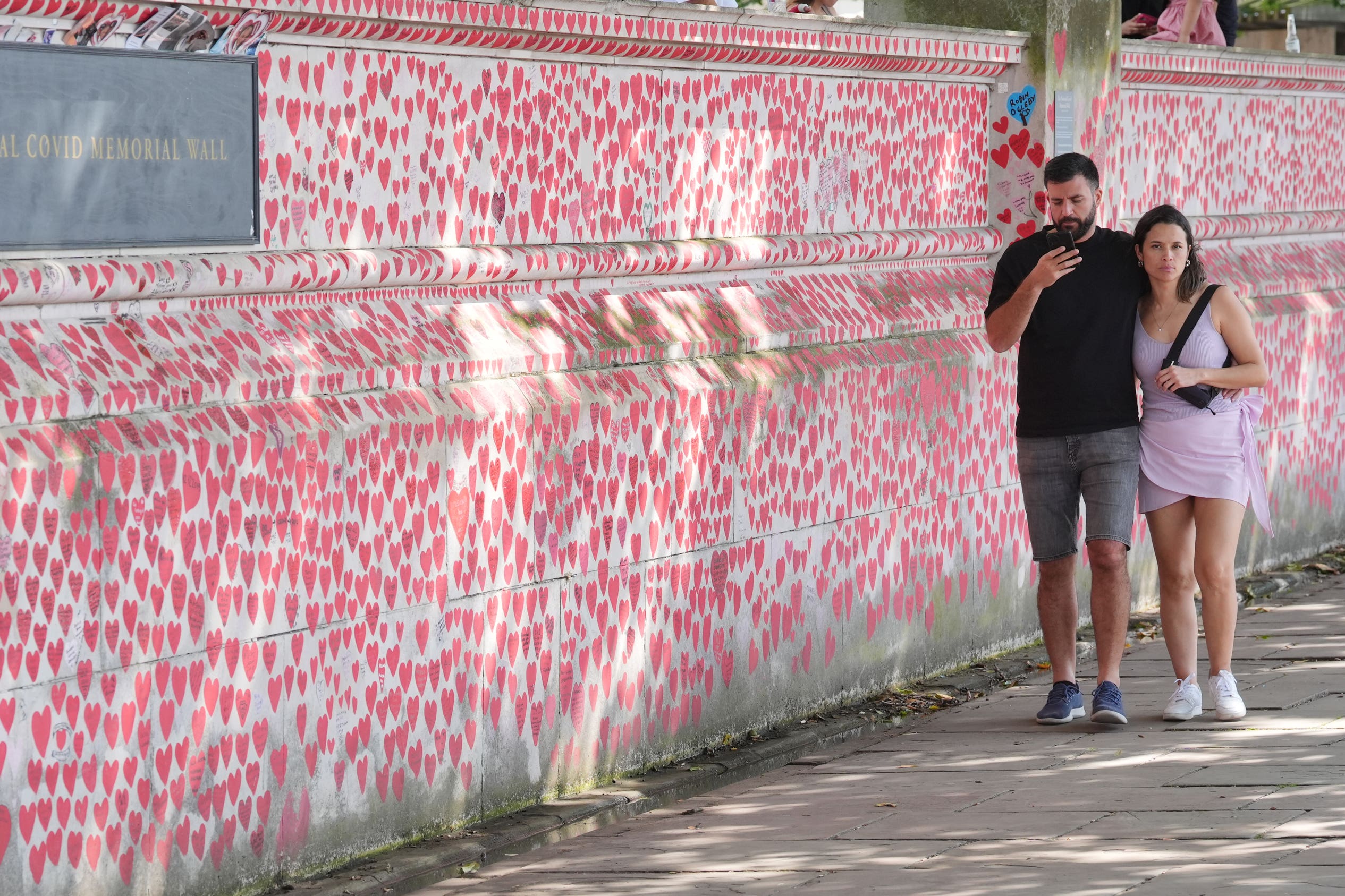 People walk past the Covid Memorial Wall in London (PA)