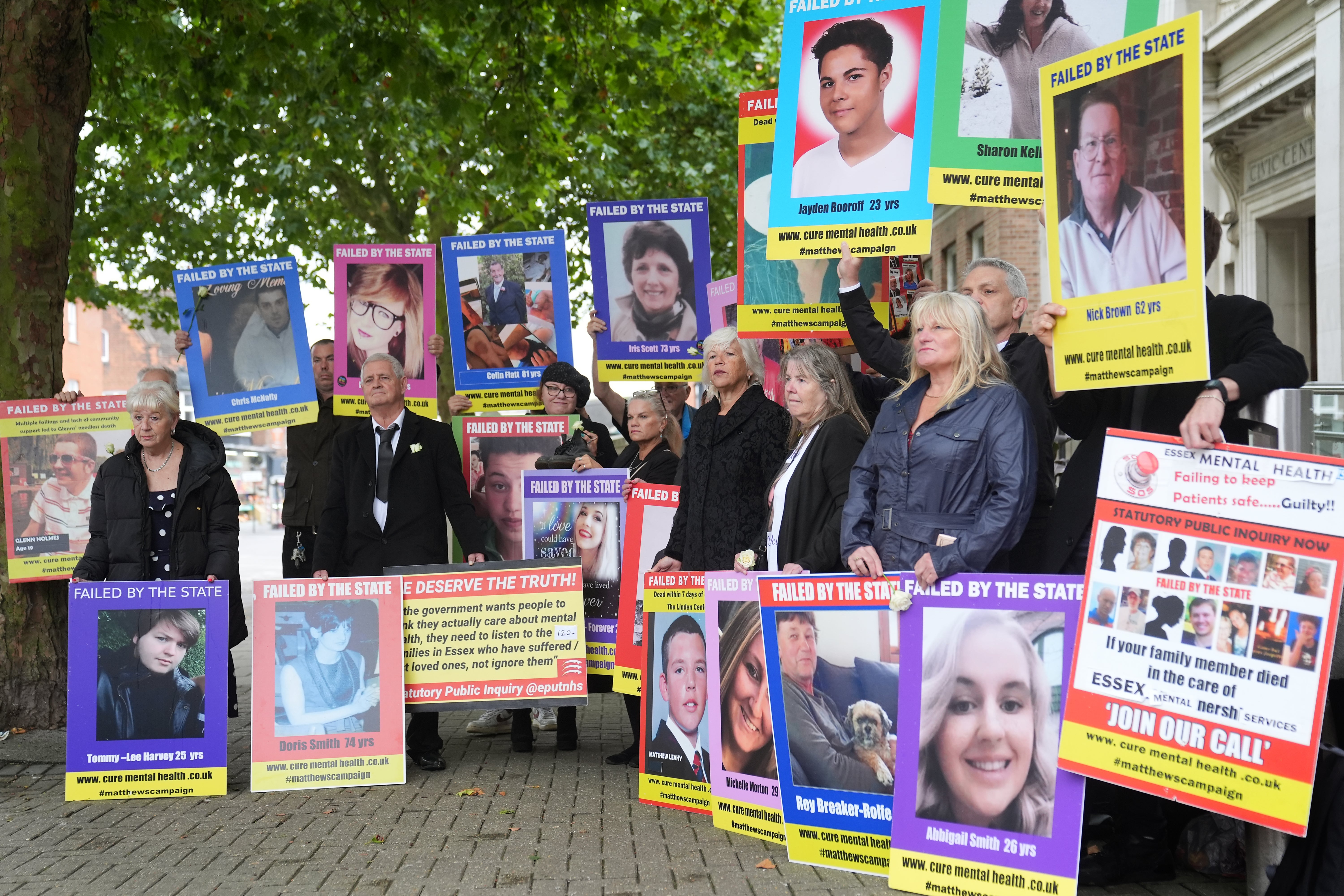 Family members of those lost after receiving treatment for mental health concerns hold up pictures during a protest outside the Lampard Inquiry at Chelmsford Civic Centre before the start of the inquiry