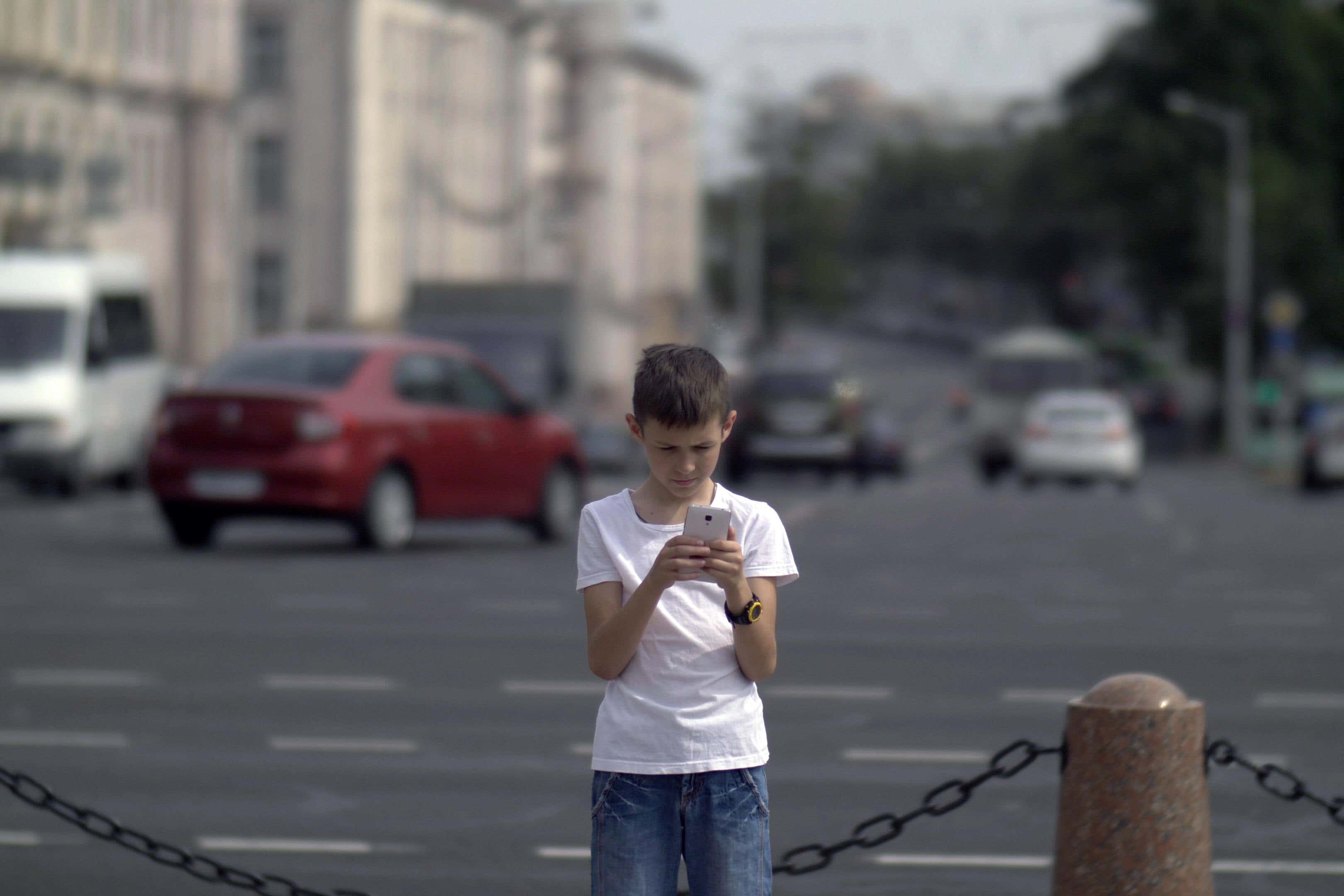 Some 84% of secondary pupils admit to using their phone when walking near roads, research found (Alamy/PA)