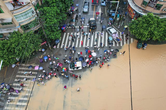 <p>File. Photo taken on 11 July 2024 shows residents being evacuated by rescue workers after rainstorms in China’s Chongqing municipality</p>