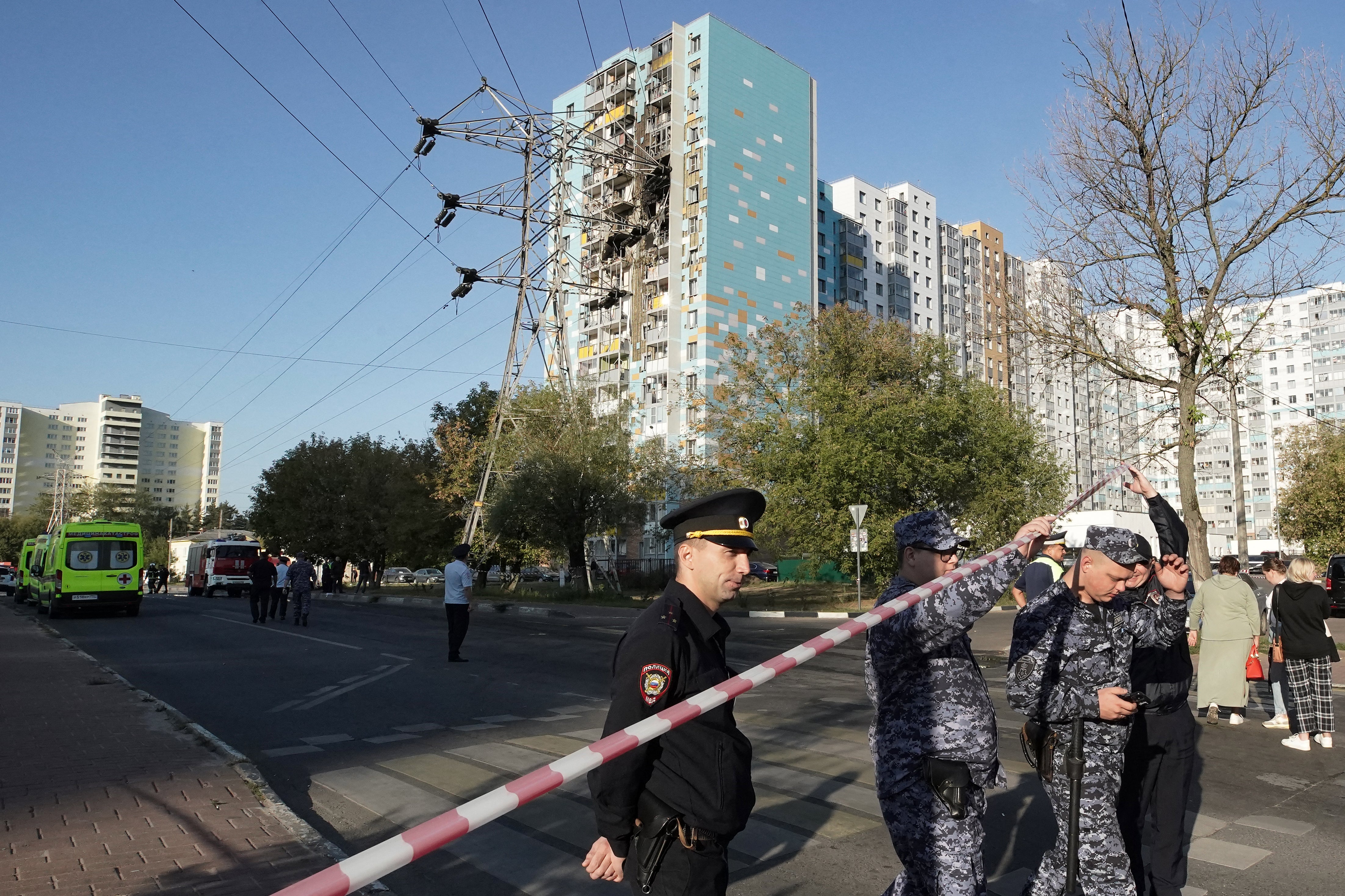 Russian police inspect the damaged residential building following a drone attack in Ramenskoye