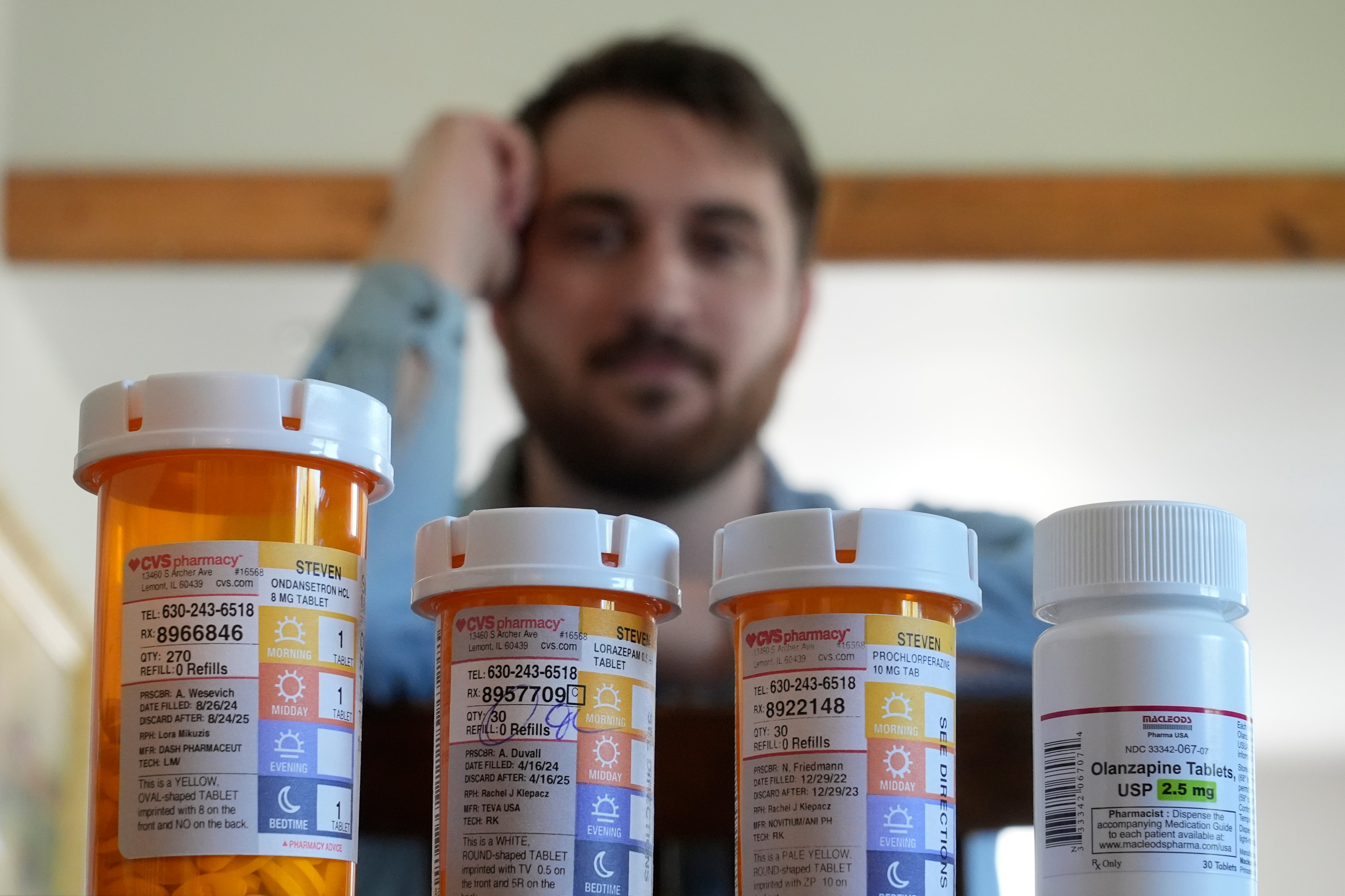 Cancer patient Steven Manetta sits for a portrait Monday, Sept. 9, 2024, in his Lemont, Ill., home with four of the five medicines he takes daily to battle the nausea from his chemotherapy