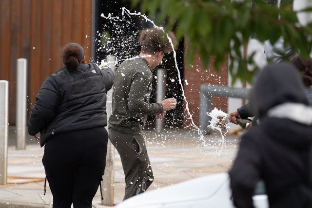 <p>People spray sparkling wine over a man who walked out of Nottingham Prison</p>