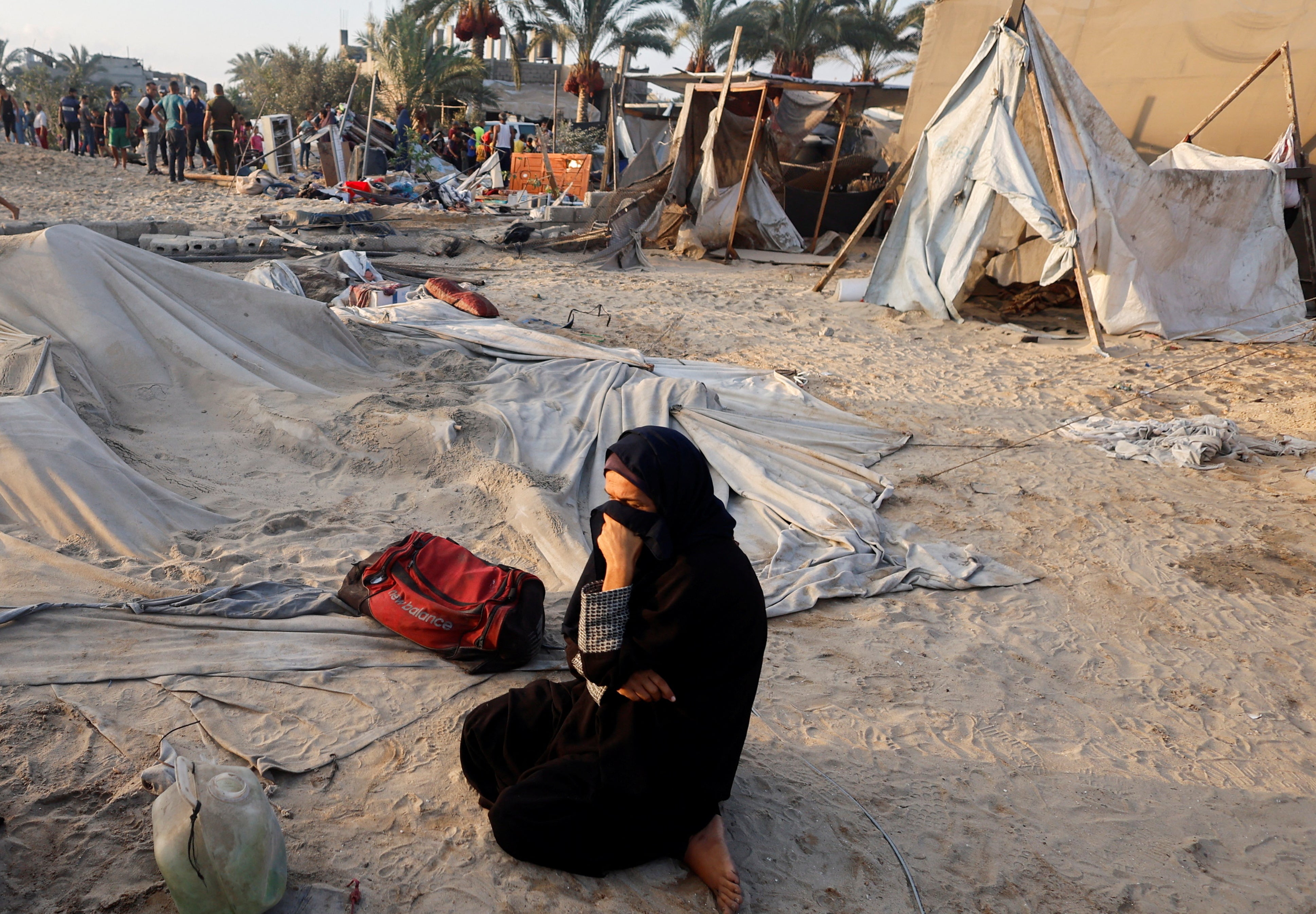 A woman sits in the aftermath of Israeli strikes on a tent camp sheltering displaced people in the al-Muwasi area of Khan Younis