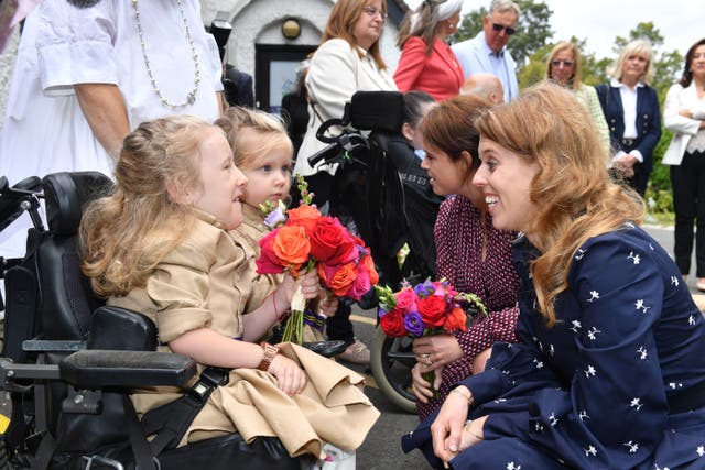 Princesses Beatrice and Eugenie were presented with flowers from Annabelle and Eva during a garden party at Haven House Children’s Hospice, Woodford Green (Theo Wood/PA)