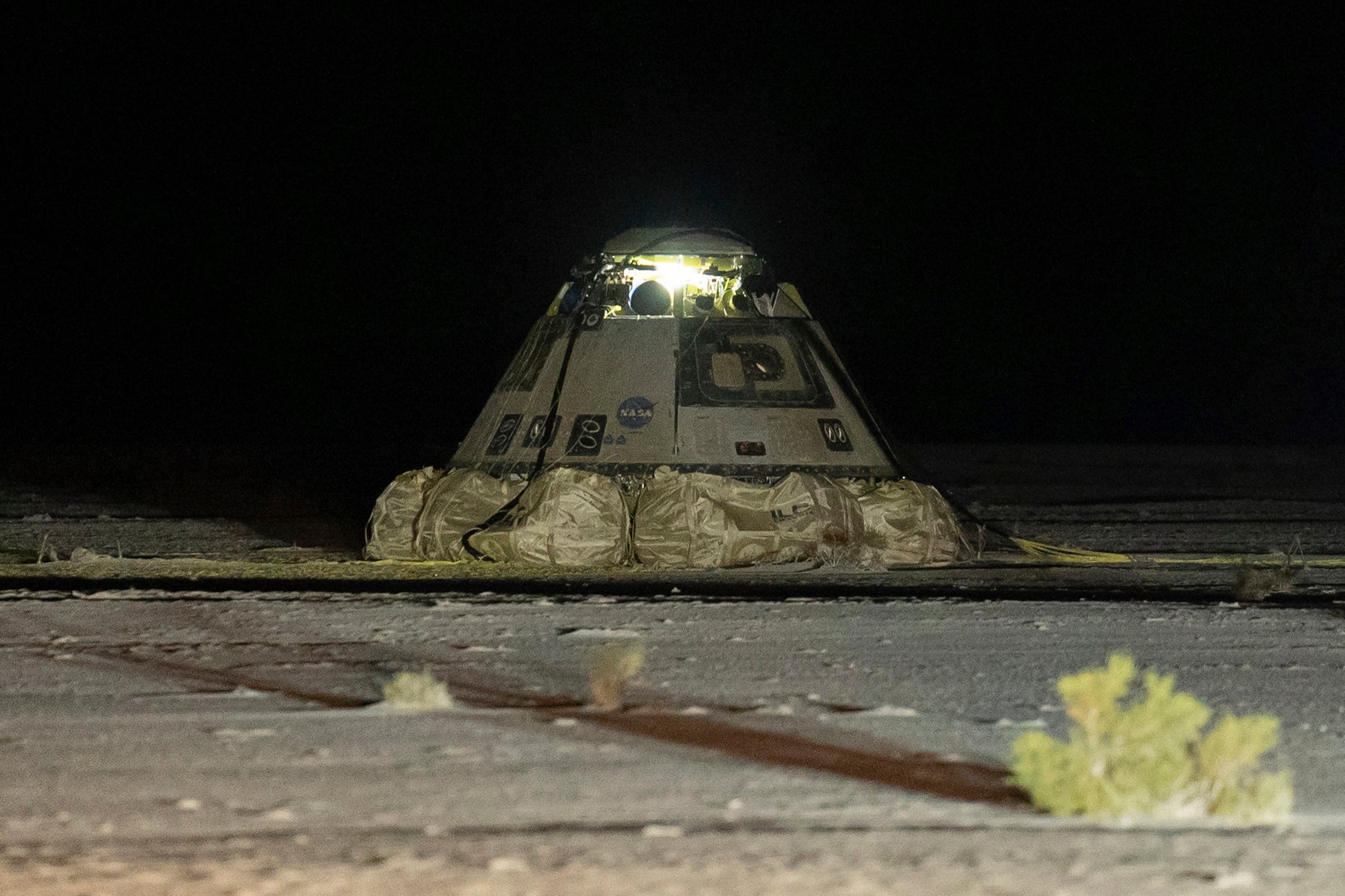 The empty Boeing Starliner capsule sits at White Sands Missile Range in New Mexico, late Friday. Its astronauts will return to Earth on a SpaceX spacecraft early next year. By that point, the pair will have been in space for nearly 250 days.