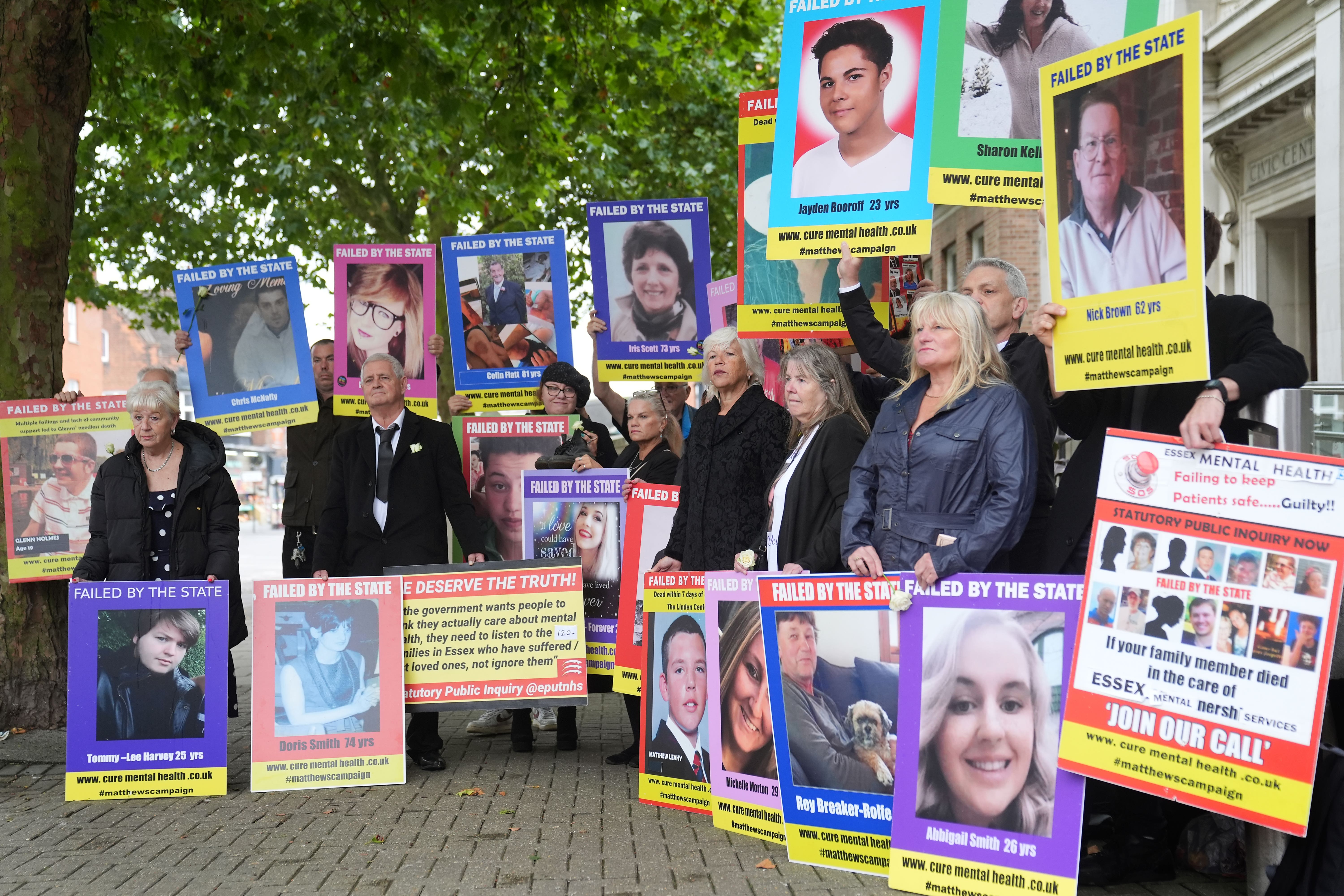 Family members hold up pictures of relatives outside the Lampard Inquiry at Chelmsford Civic Centre on Monday (Joe Giddens/PA)