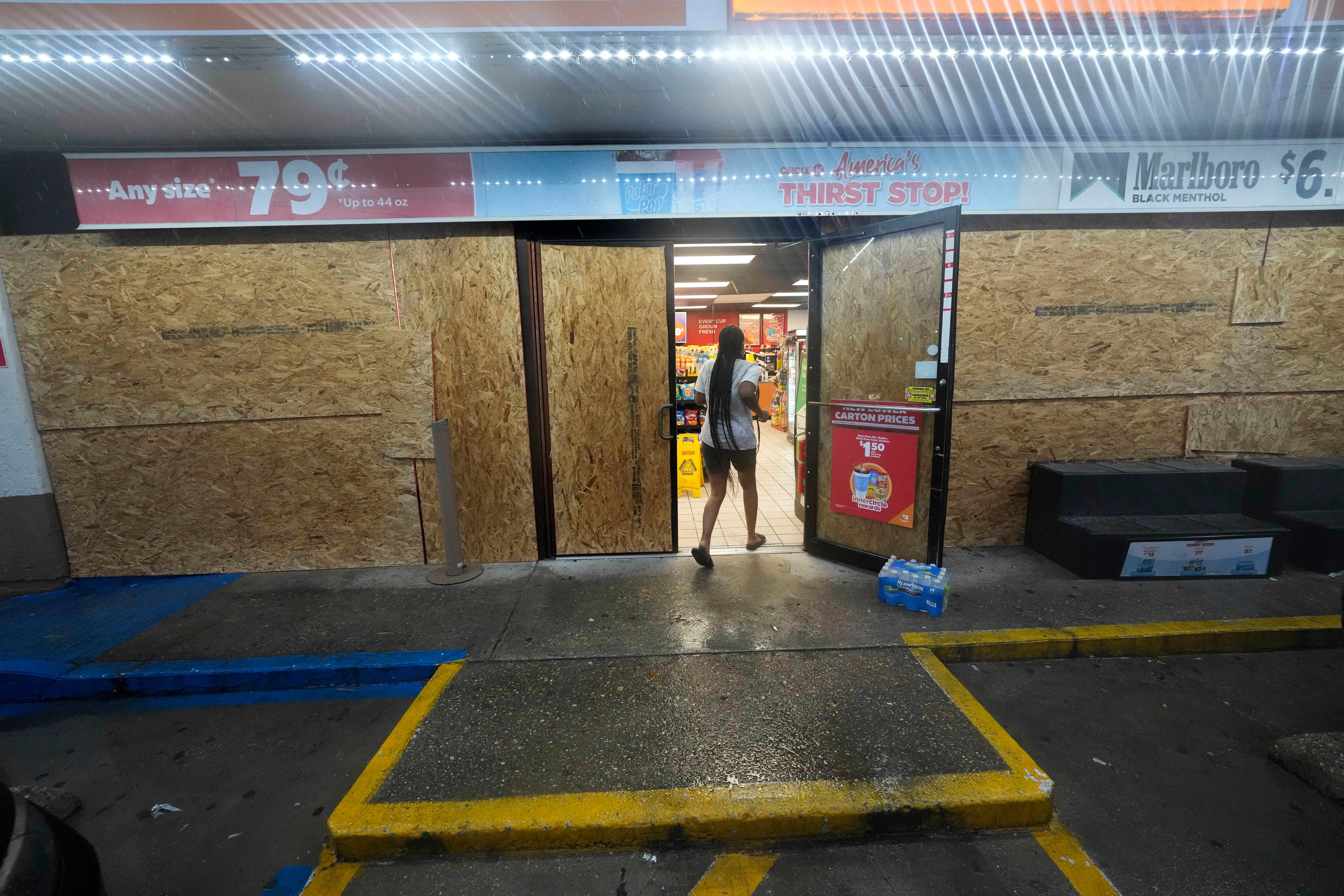 A customer enters a boarded up gas station in Morgan City, Louisiana, on Wednesday. The path of the storm had shifted east since Tuesday, and would now impact the area.