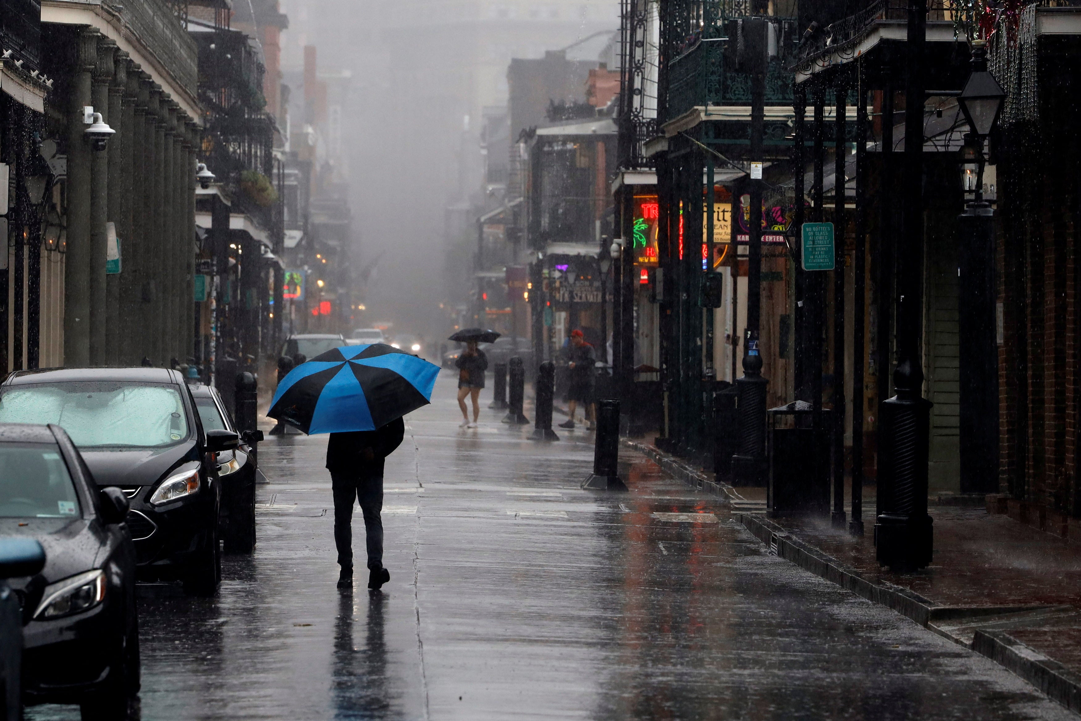 A pedestrian carrying an umbrella walks down Bourbon Street in New Orleans on Wednesday. New Orleans is expected to see flooding from the Category 2 Hurricane Francine.