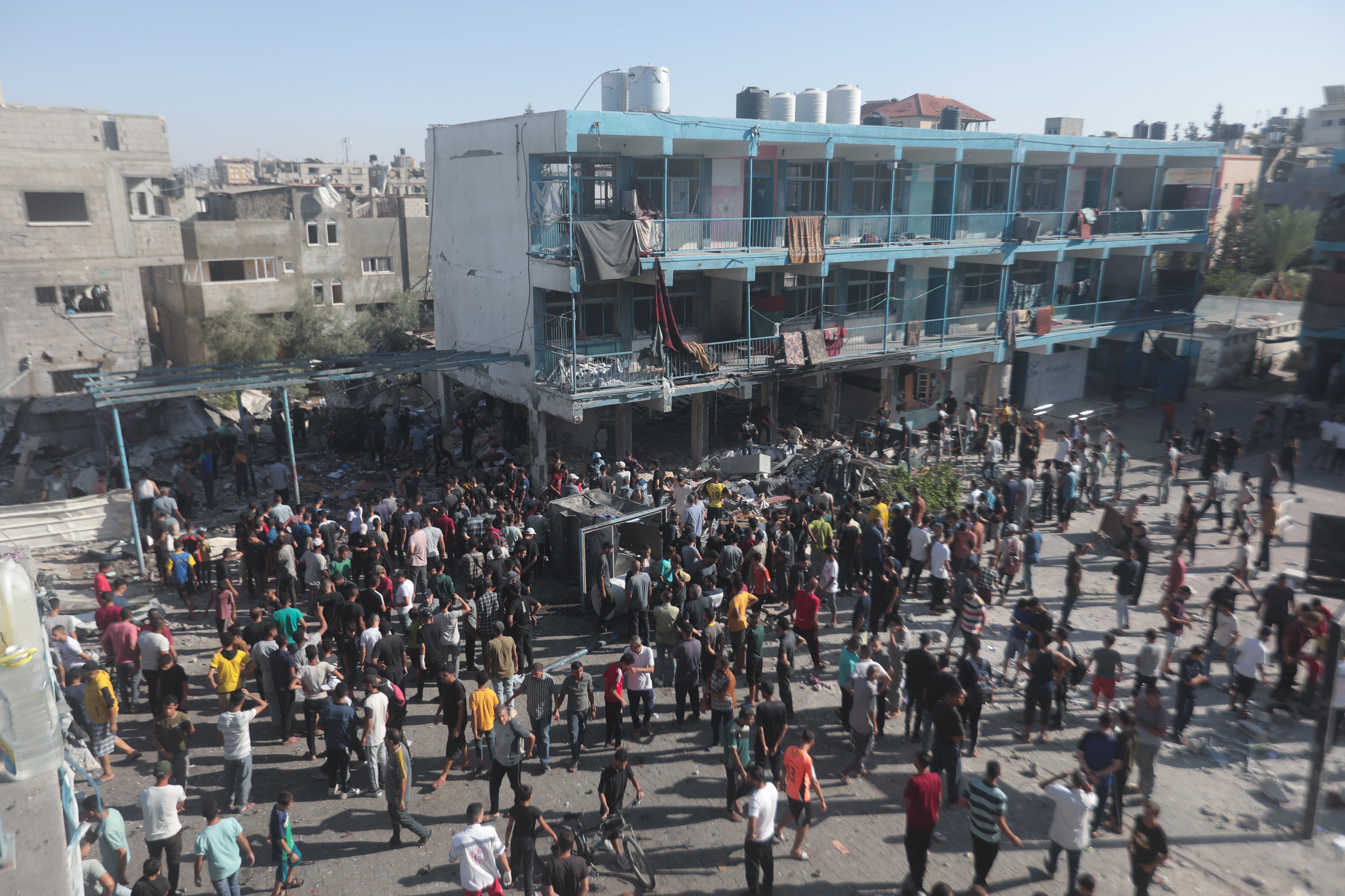 Civil defence teams and civilians carry out search and rescue work after an Israeli attack on a UN school sheltering displaced Palestinians in Gaza