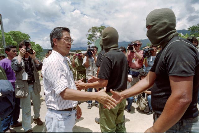 <p>Then-Peruvian president Alberto Fujimori shakes hands with one of the leaders of a group of Shining Path guerrillas who surrendered in 1992</p>